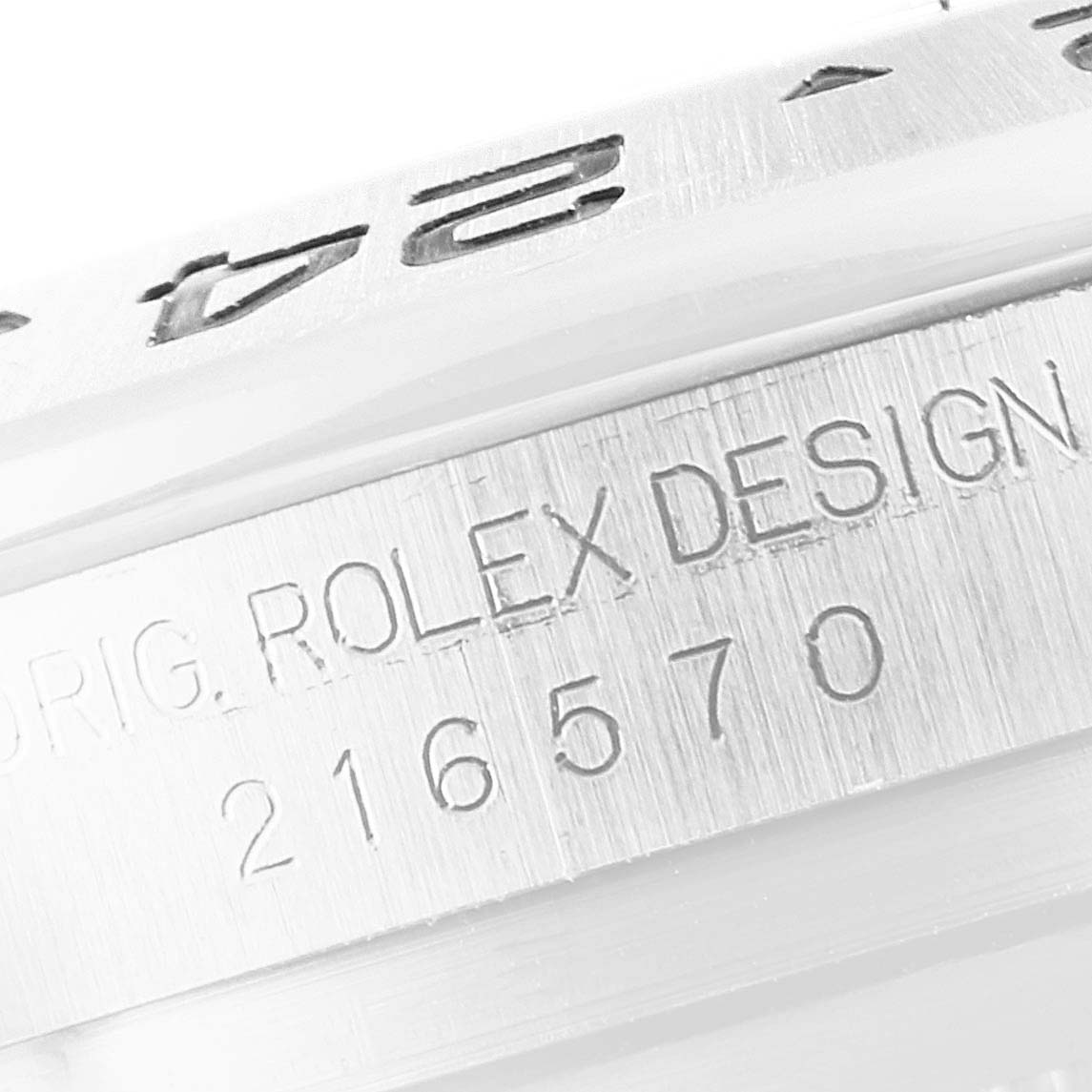 The image shows a close-up of the Rolex Explorer 216570 Men's Stainless Steel Black Dial 216570 Men's Stainless Steel Black Dial model's bezel and engraved serial number.