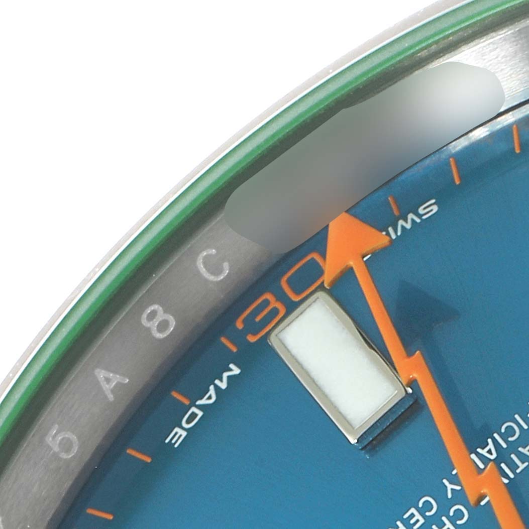 The image shows a close-up of the dial edge and orange lightning-bolt second hand of a Rolex Milgauss 116400GV Men's Stainless Steel Blue Dial 116400GV Men's Stainless Steel Blue Dial watch.