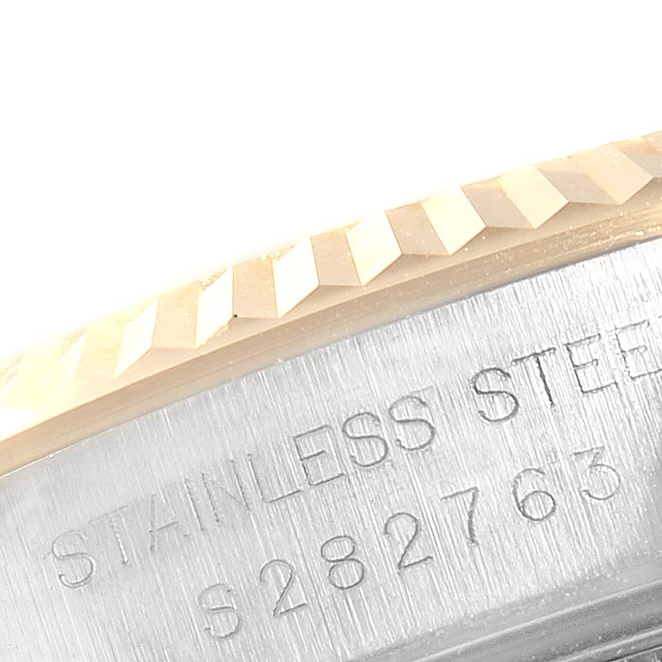 This close-up image shows the fluted bezel and part of the engraved case back of a Rolex Oyster Perpetual 67193 Women's Stainless Steel Black Dial 67193 Women's Stainless Steel Black Dial watch.