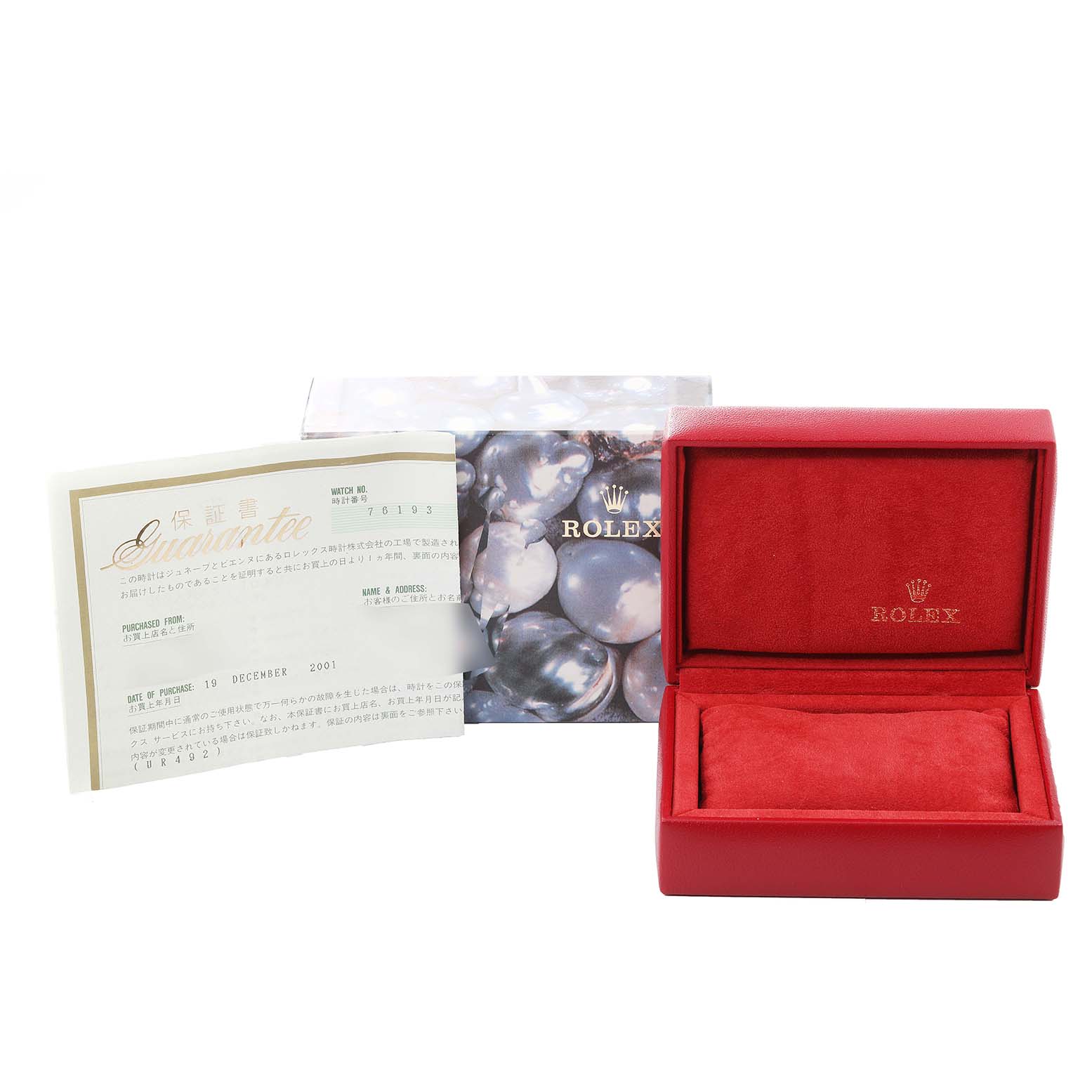 The image shows an empty red Rolex box and a warranty card for the Oyster Perpetual model by Rolex.