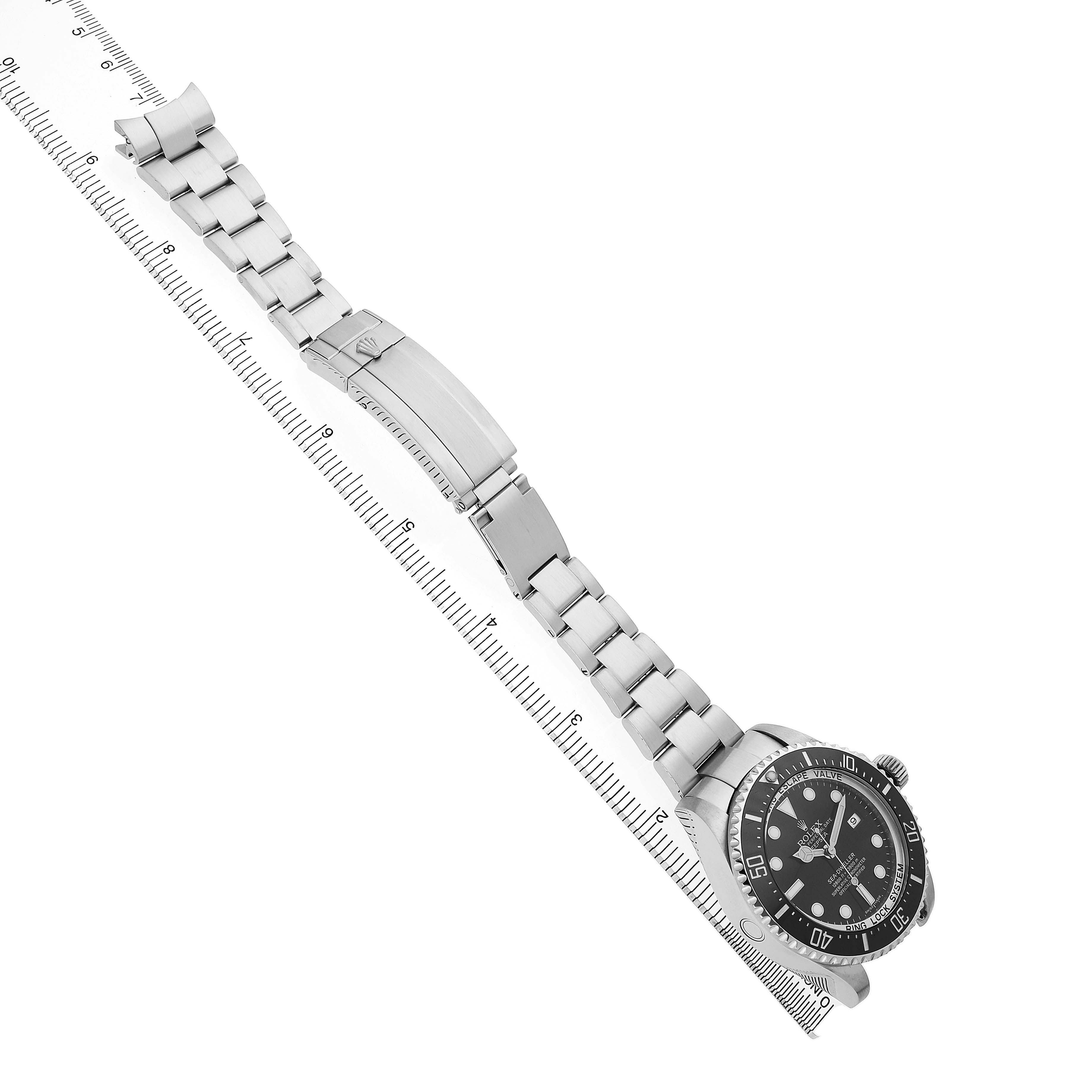 The image shows a Rolex Sea-Dweller 116660 Men's Stainless Steel Black Dial watch laid flat, highlighting the bracelet, clasp, and face, with a ruler for scale.