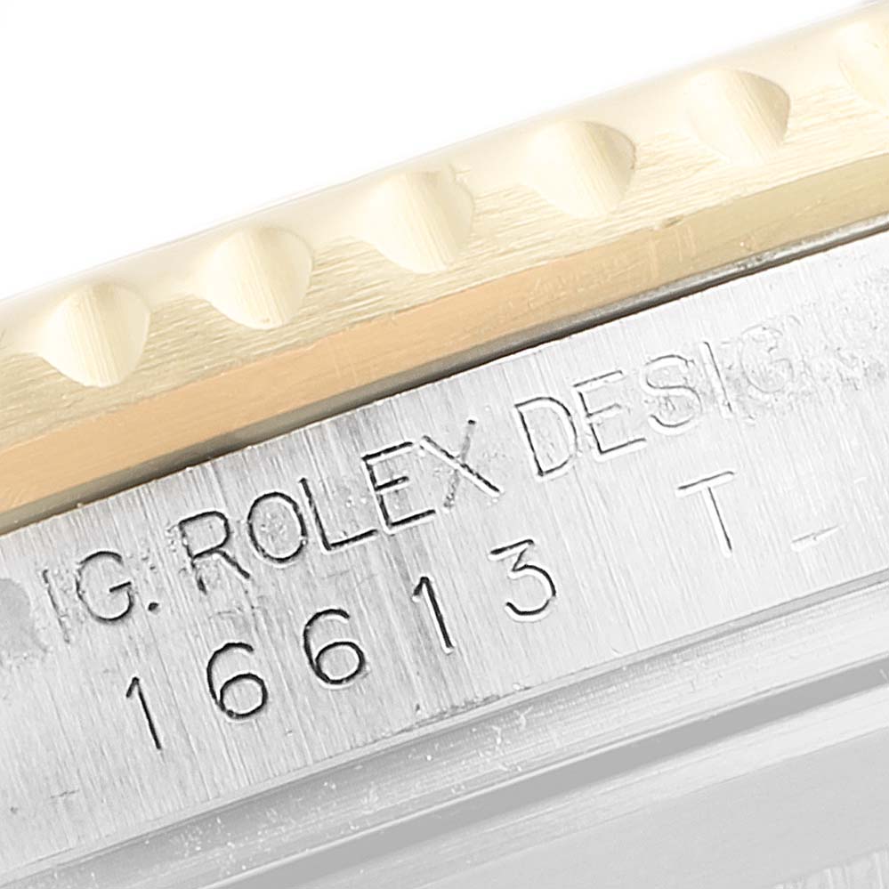 This image shows a close-up of the engraved side of a Rolex Submariner 16613 Men's Steel and Gold (two tone) Black Dial 16613 Men's Steel and Gold (two tone) Black Dial model 16613, focusing on the bezel and case.
