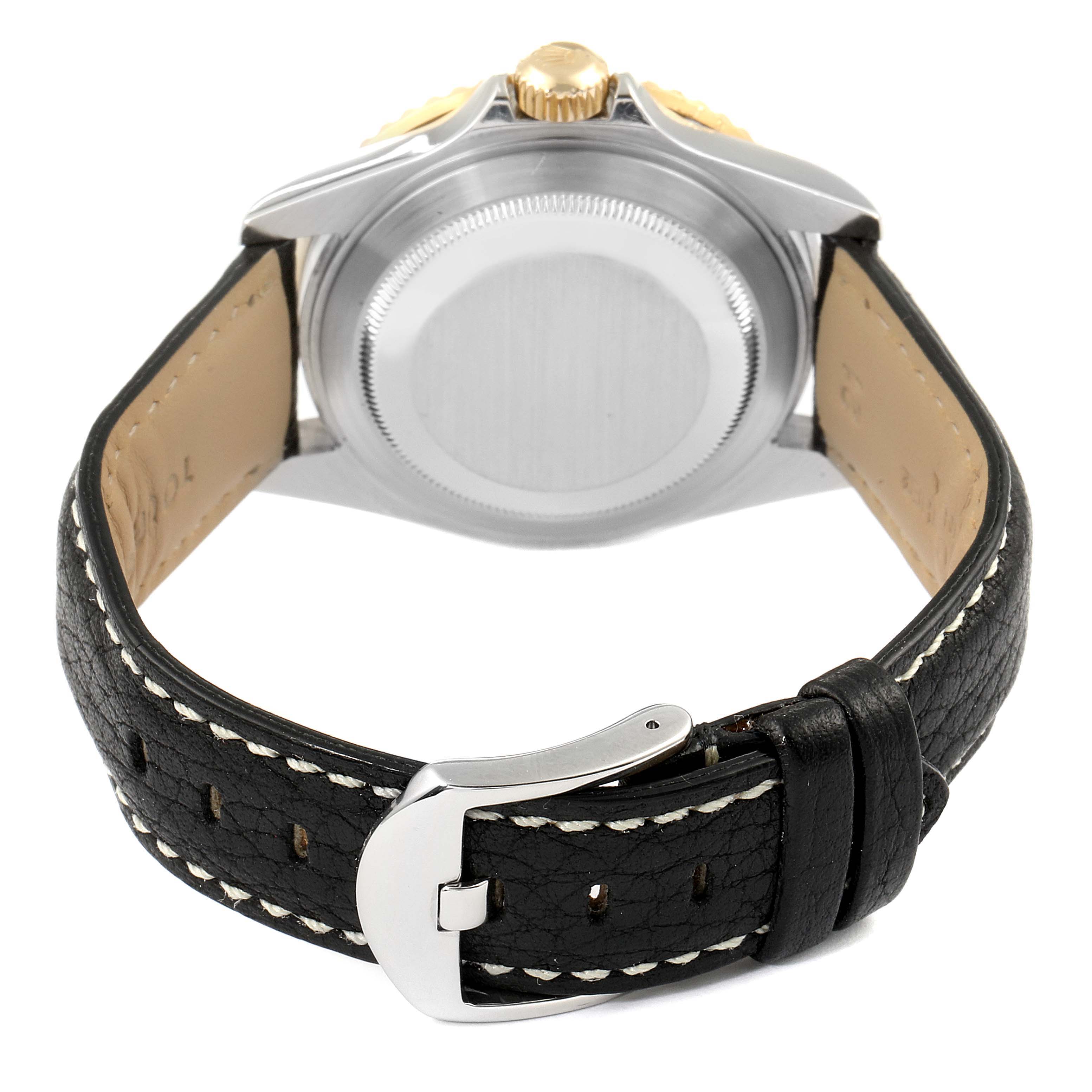 The image shows the back of a Rolex Submariner 16613 Men's Steel and Gold (two tone) Black Dial 16613 Men's Steel and Gold (two tone) Black Dial watch, featuring the case back and leather strap with a buckle.