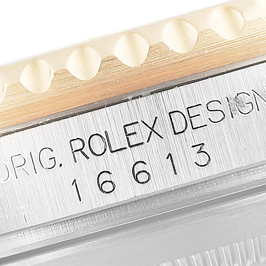 The image shows a close-up of the edge bezel and case text of a Rolex Submariner 16613 Men's Steel and Gold (two tone) Blue Dial 16613 Men's Steel and Gold (two tone) Blue Dial model 16613.