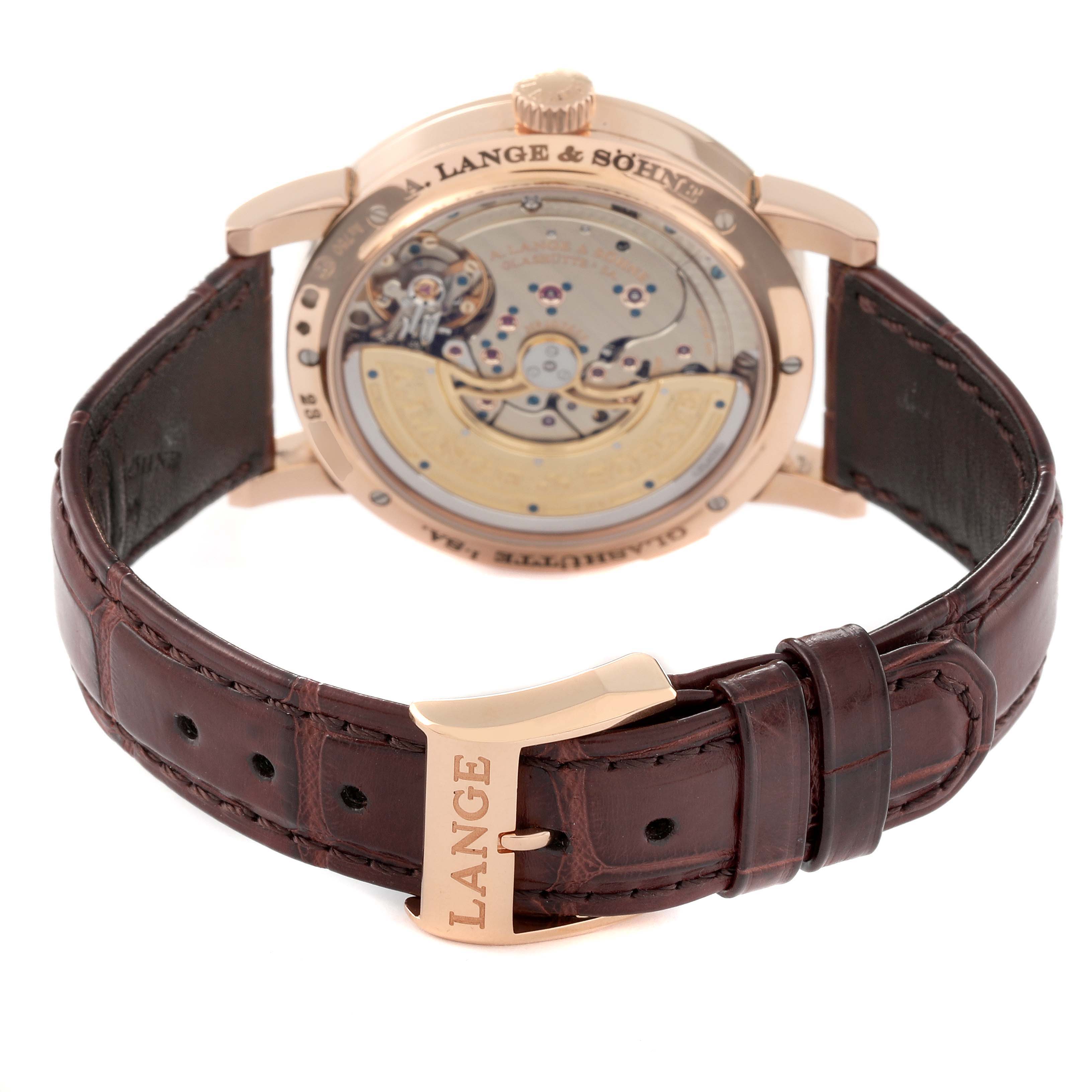 The image shows the back view of a Lange 1 model by A. Lange & Söhne, highlighting the movement and leather strap with a branded buckle.