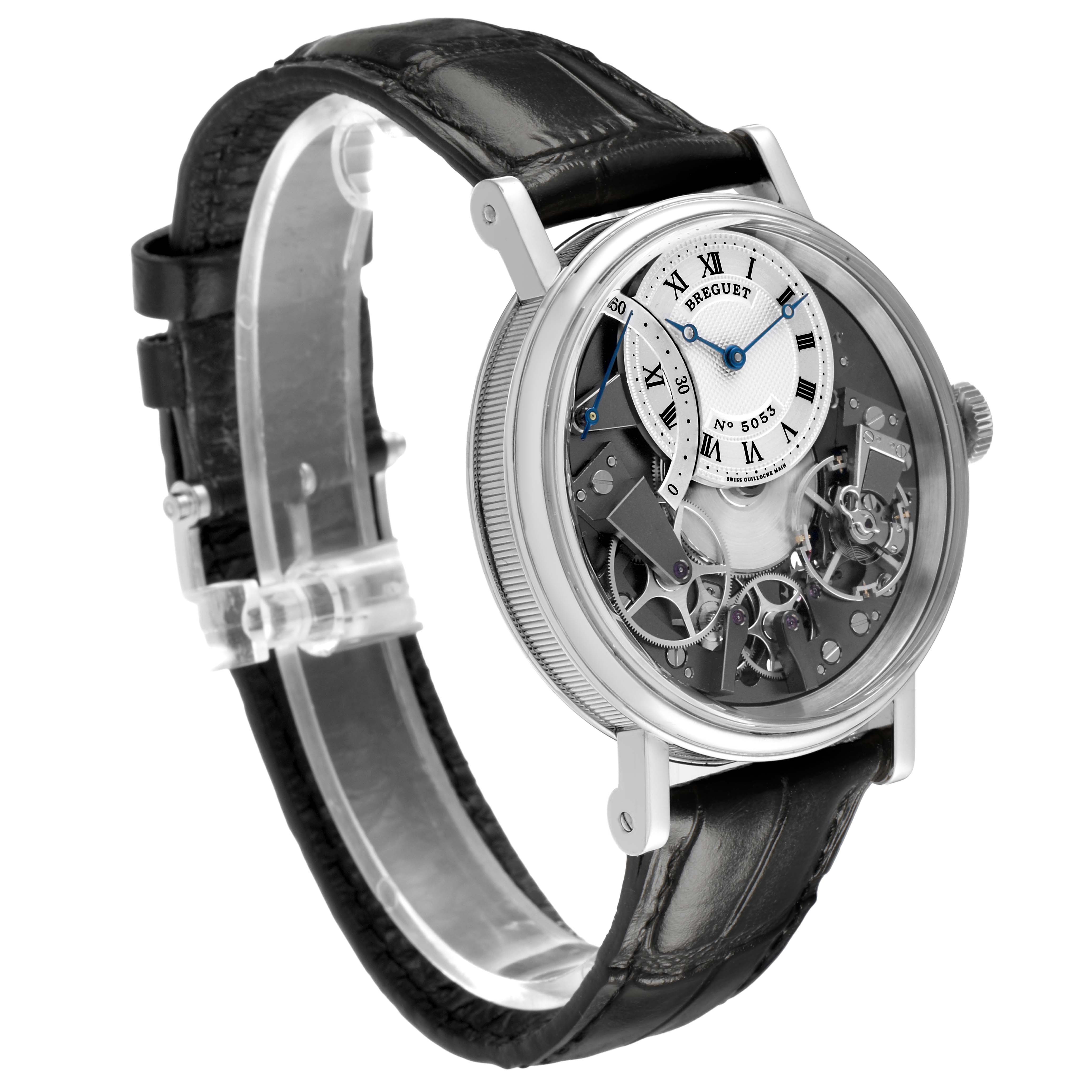 The Breguet Tradition 7097 Men's White Gold Silver Dial watch is shown at a three-quarter angle, highlighting its dial, mechanical components, and leather strap.