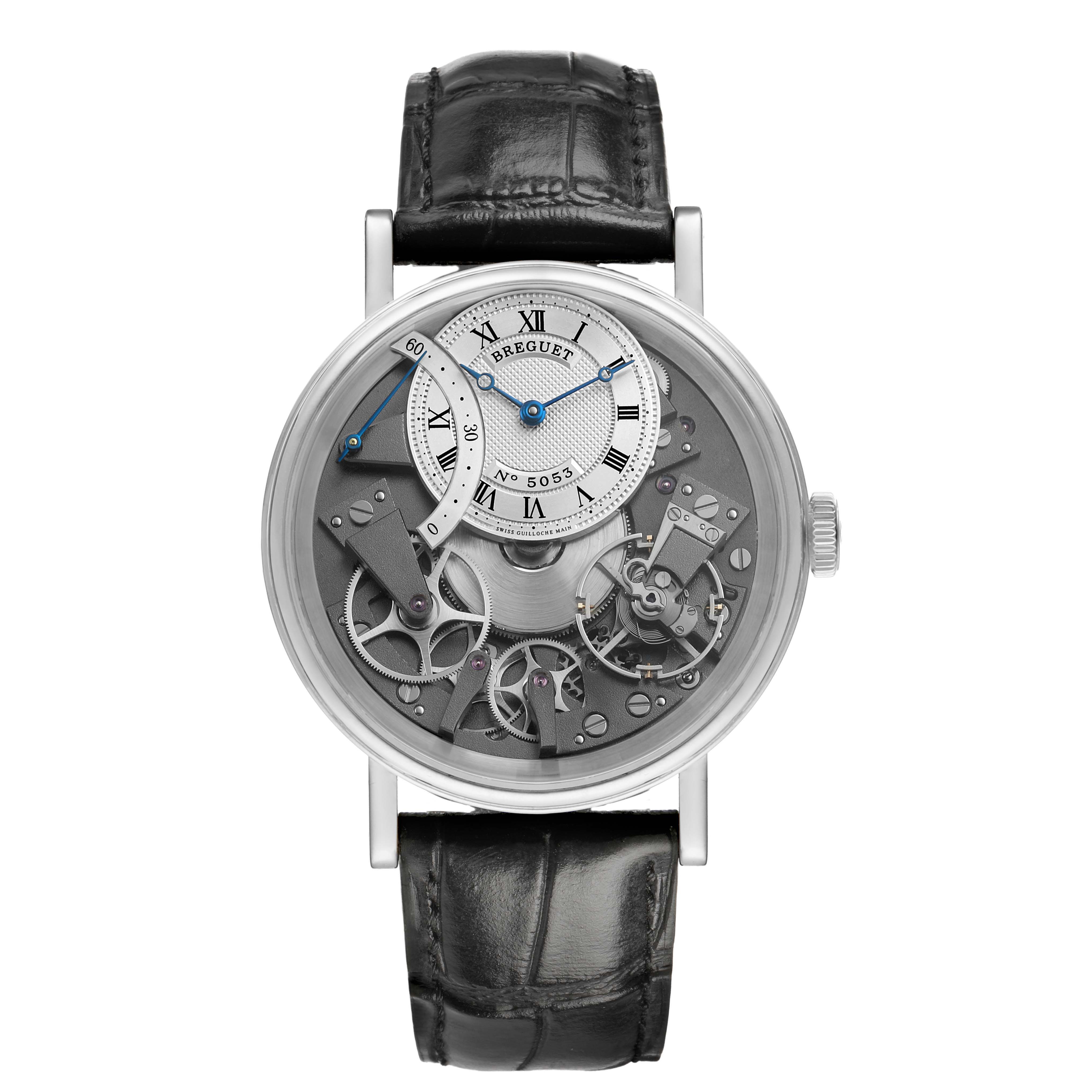 The Breguet Tradition 7097 Men's White Gold Silver Dial model watch is shown from a front angle, highlighting its open mechanism and Roman numeral dial.