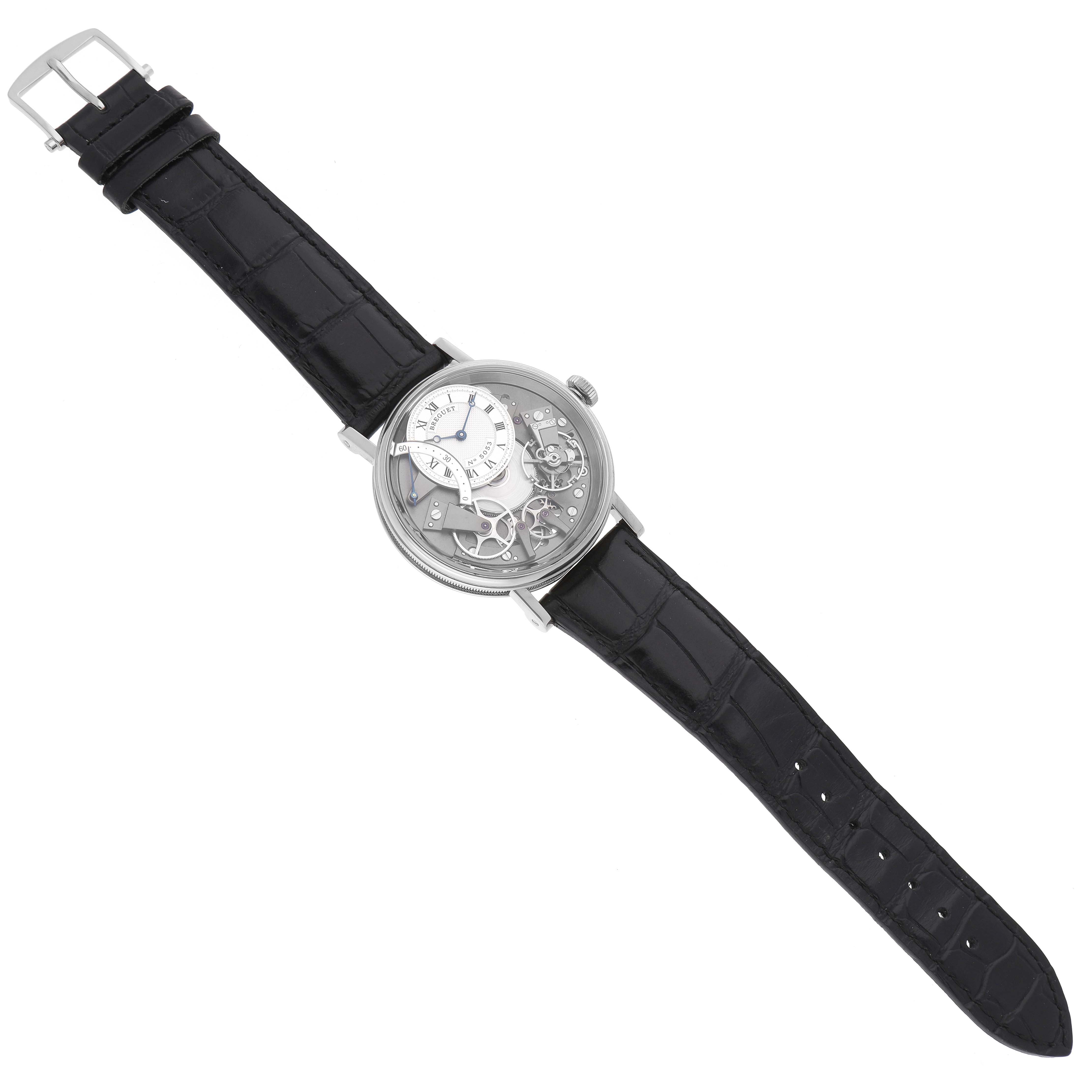 The Breguet Tradition 7097 Men's White Gold Silver Dial watch is shown from a top-down angle, displaying its intricate dial and black leather strap.