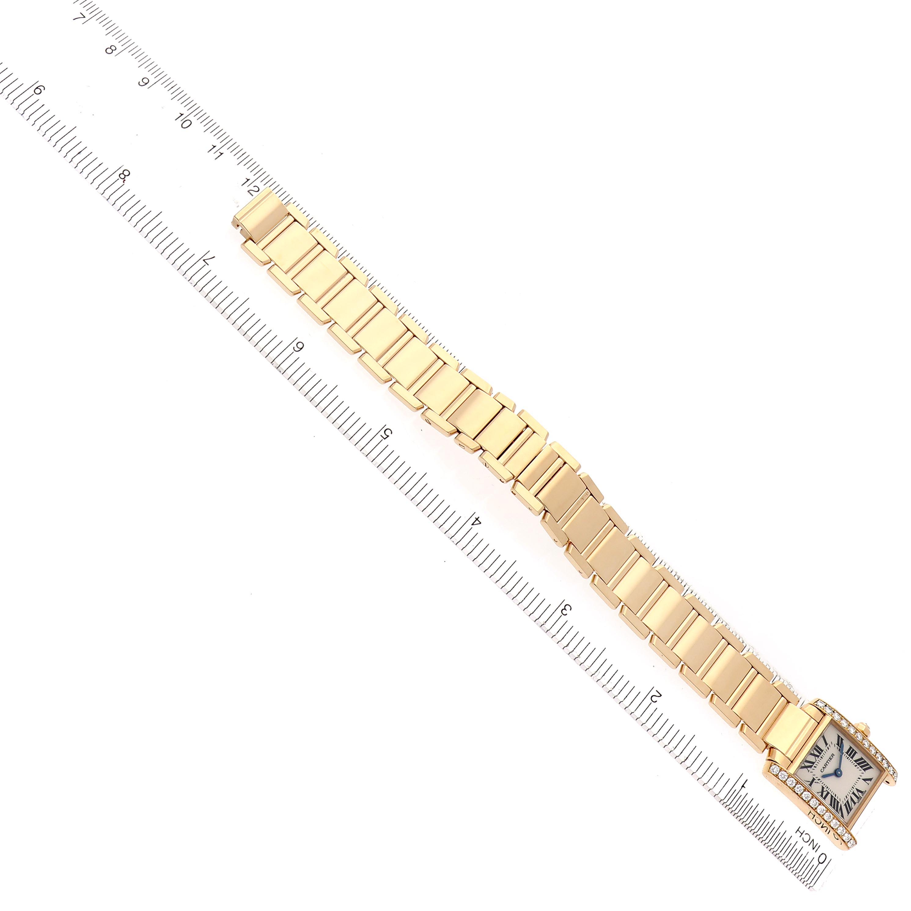 The Cartier Tank Francaise WE1001R8 Women's Yellow Gold Silver Dial WE1001R8 Women's Yellow Gold Silver Dial watch is shown from a top-down angle, displaying the full face and gold bracelet against a ruler.