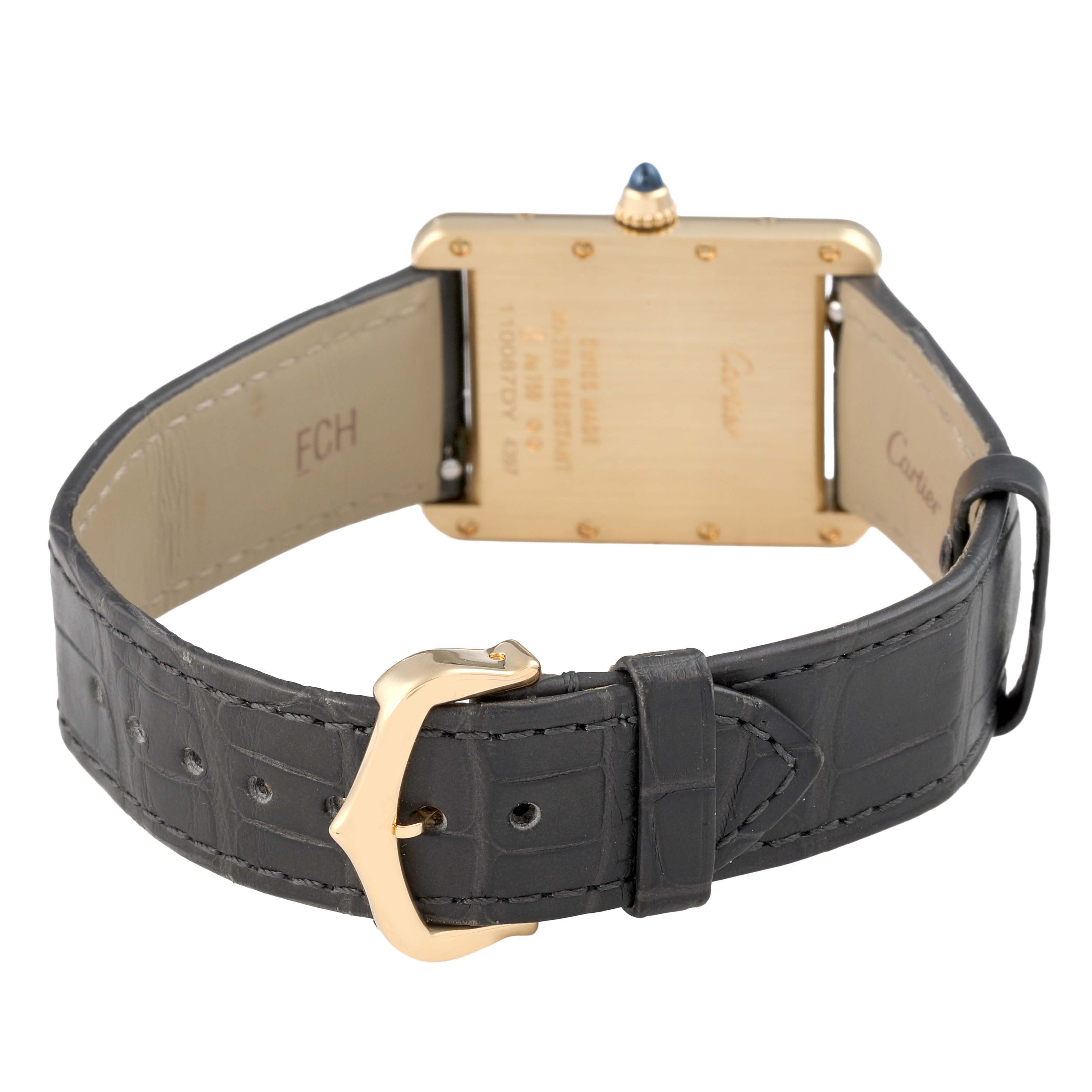 The Cartier Tank Louis WGTA0067 Men's Yellow Gold Silver Dial watch is shown from the back, highlighting the case, leather strap, buckle, and crown with a blue gem.