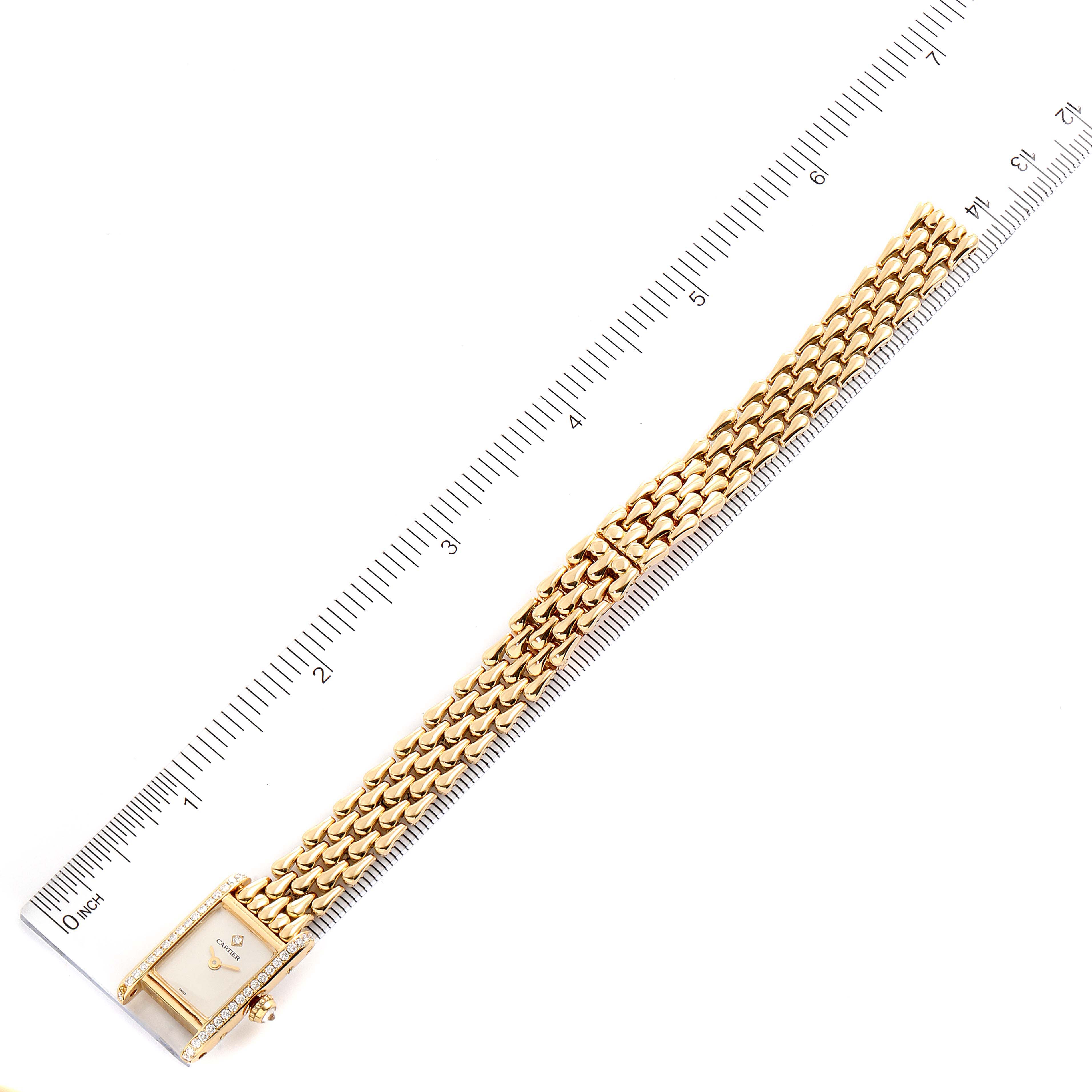 The image shows a Cartier Tank Louis 1360.1 Women's Yellow Gold Silver Dial 1360.1 Women's Yellow Gold Silver Dial watch laying flat next to a measuring scale, displaying the face and entire bracelet.