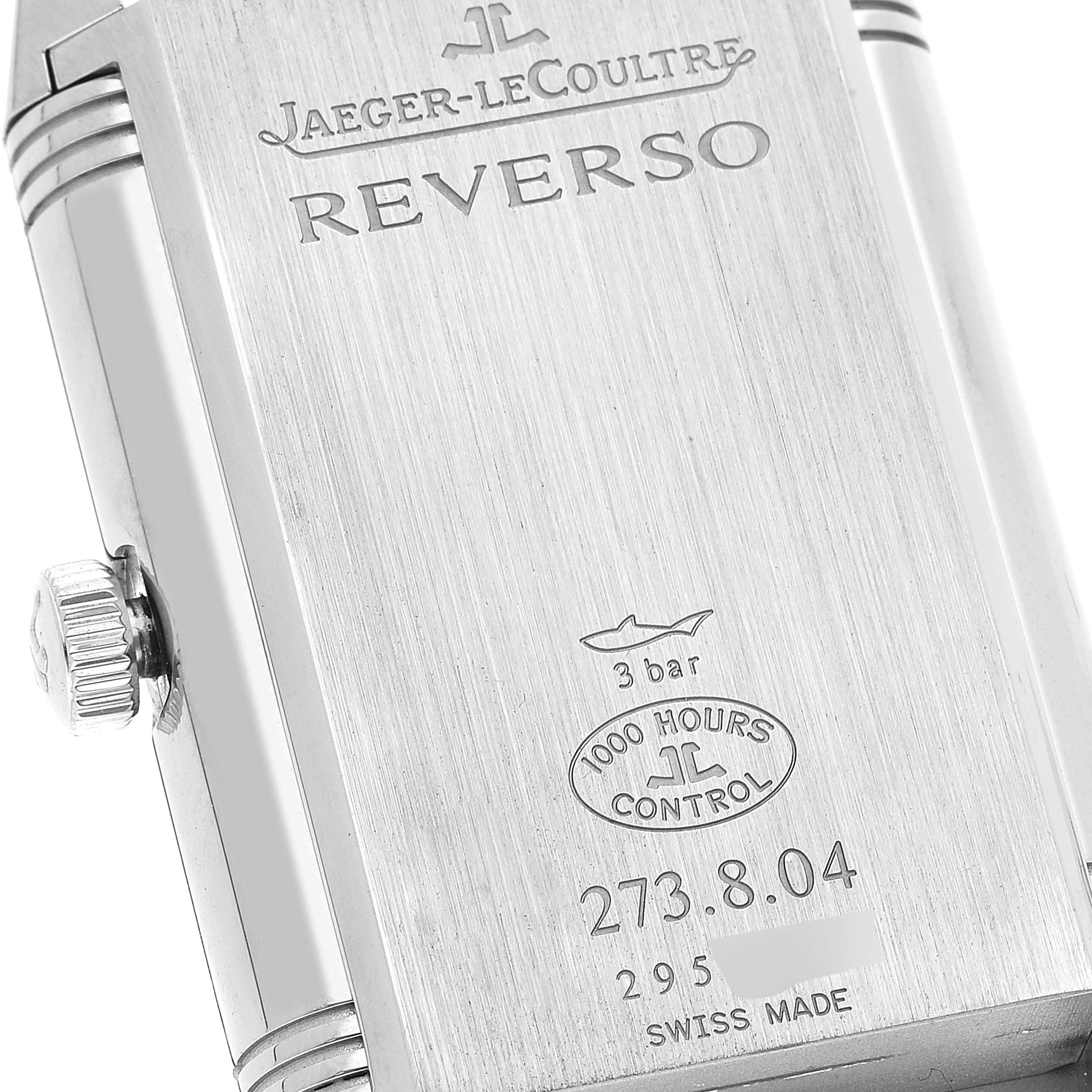 This image shows the back of a Jaeger-LeCoultre Reverso watch, including the crown and engravings.