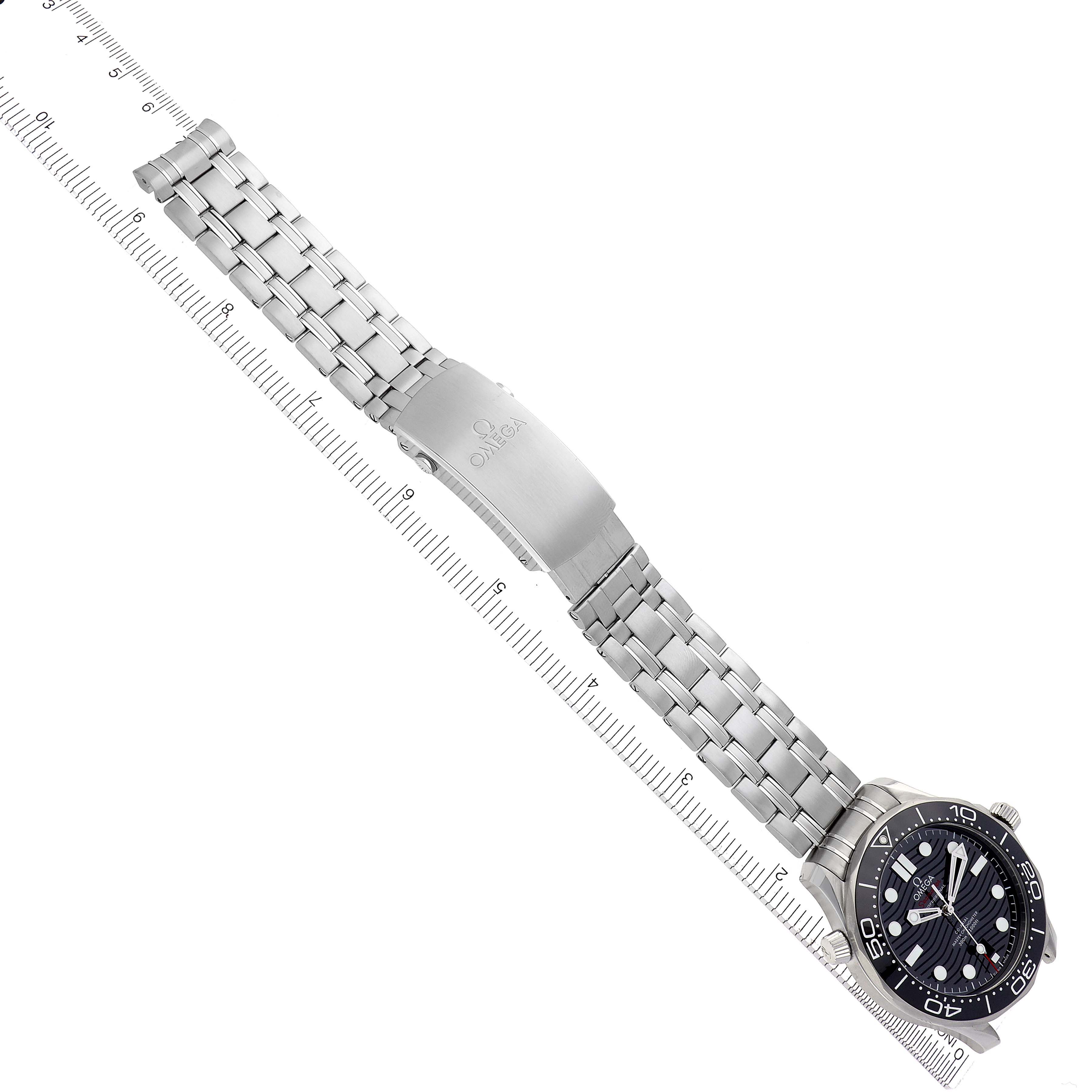 The Omega Seamaster 210.30.42.20.01.001 Men's Stainless Steel Black Dial 210.30.42.20.01.001 Men's Stainless Steel Black Dial watch is displayed diagonally, showing the full bracelet and clasp, with a ruler for scale.