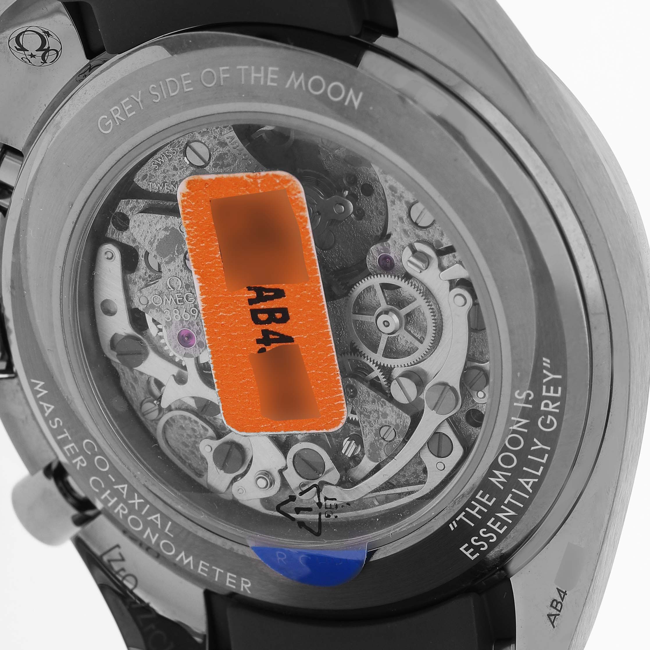 The image shows the back of an Omega Speedmaster 310.92.44.50.06.002 Men's Ceramic Grey Dial, revealing its movement through a transparent case back.