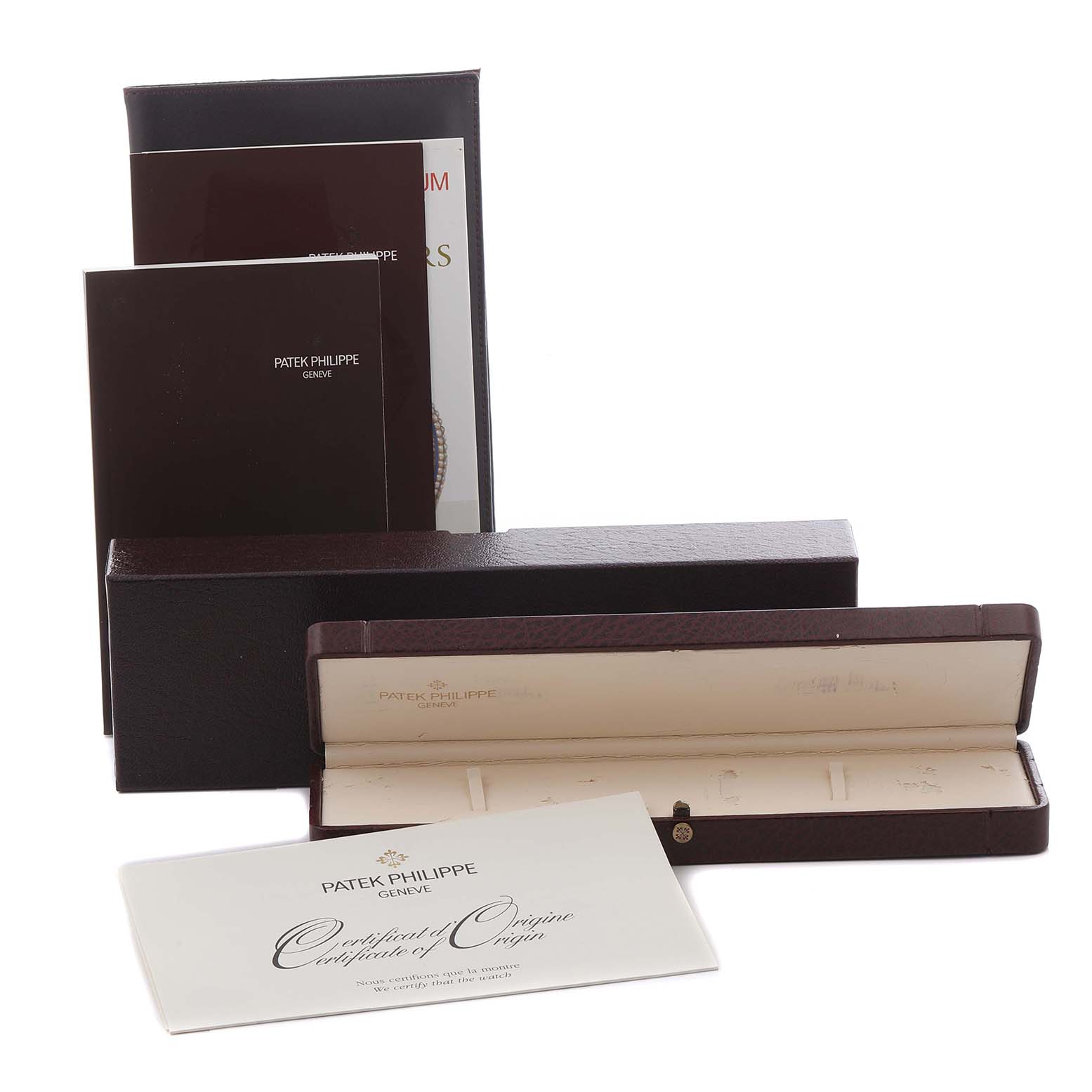 The image shows accessories for a Patek Philippe Calatrava 5134R-001 Men's Rose Gold White Dial 5134R-001 Men's Rose Gold White Dial, including the box, papers, and a certificate.