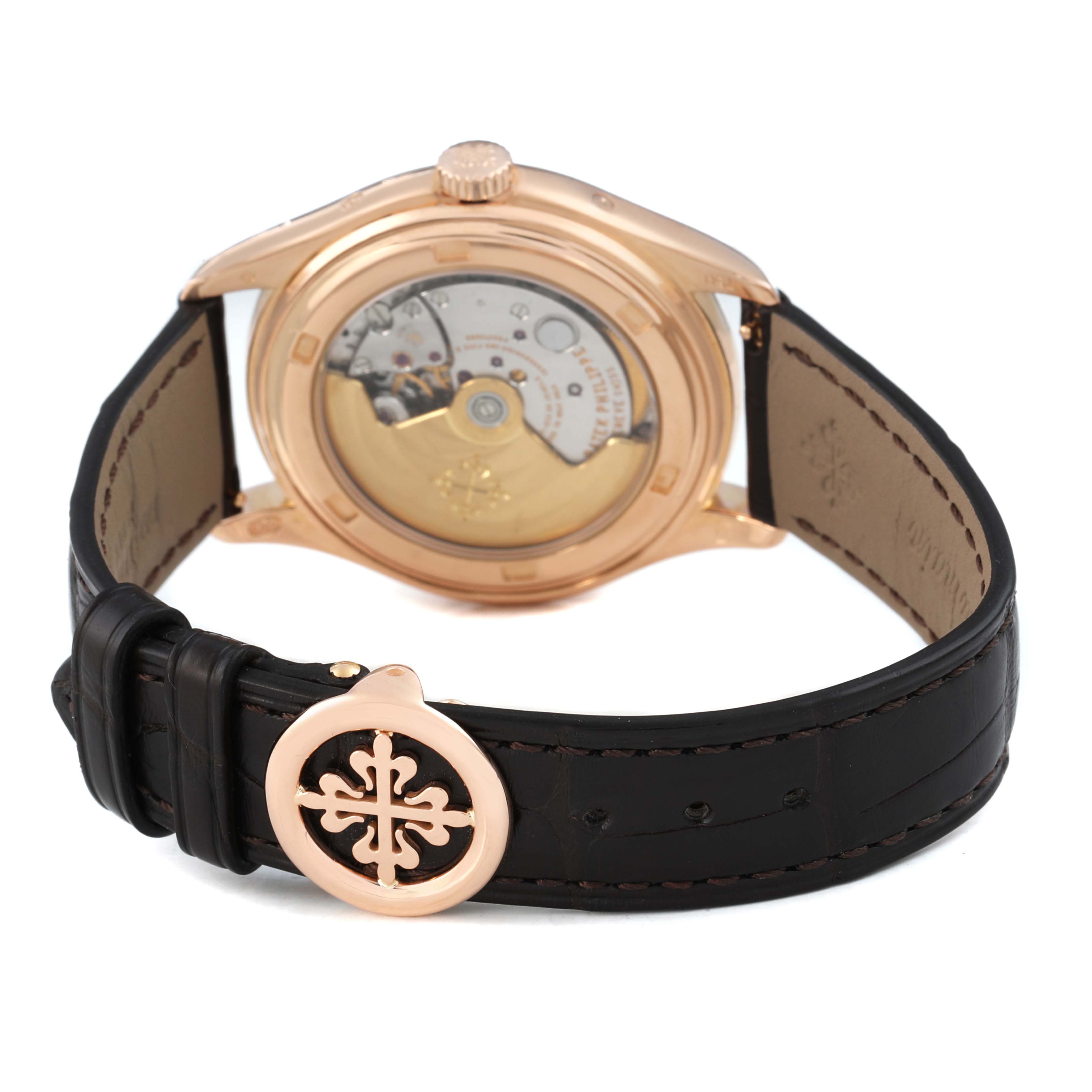 The Patek Philippe Complications 5146R-001 Men's Rose Gold Beige Dial watch is shown from the back, highlighting the movement and deployment clasp engraved with the brand's logo.