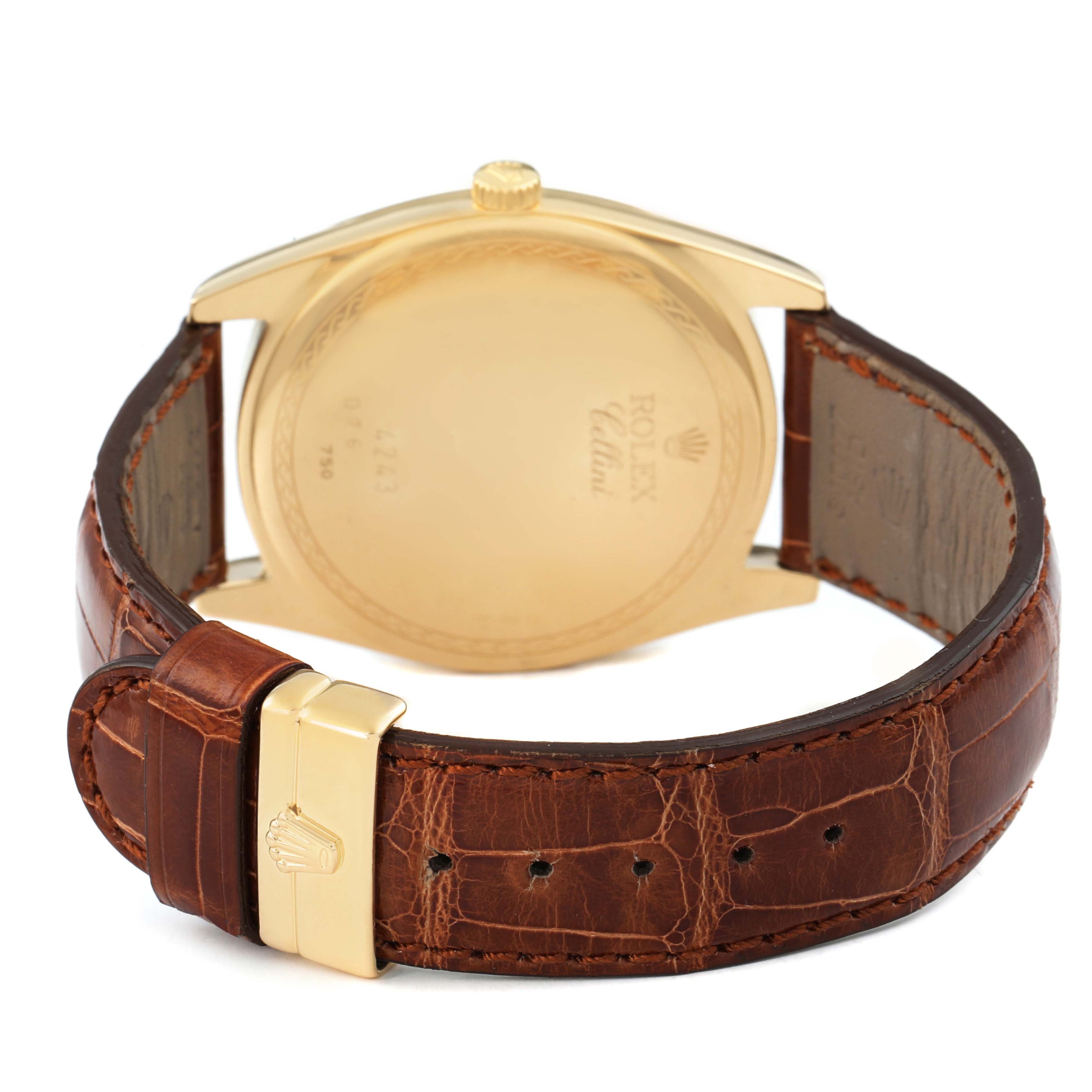 The Rolex Cellini 4243 Men's Yellow Gold Champagne Dial watch is shown from the back, displaying the case back, crown, and leather strap with a gold clasp.
