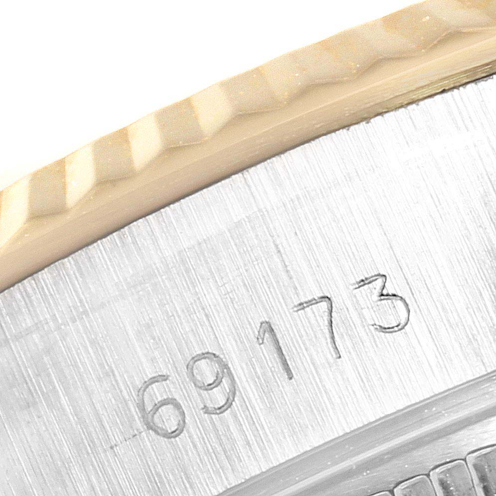 This image shows a close-up of the model number engraving and fluted bezel of a Rolex Datejust 69173  Women's Stainless Steel Champagne Dial 69173  Women's Stainless Steel Champagne Dial watch.