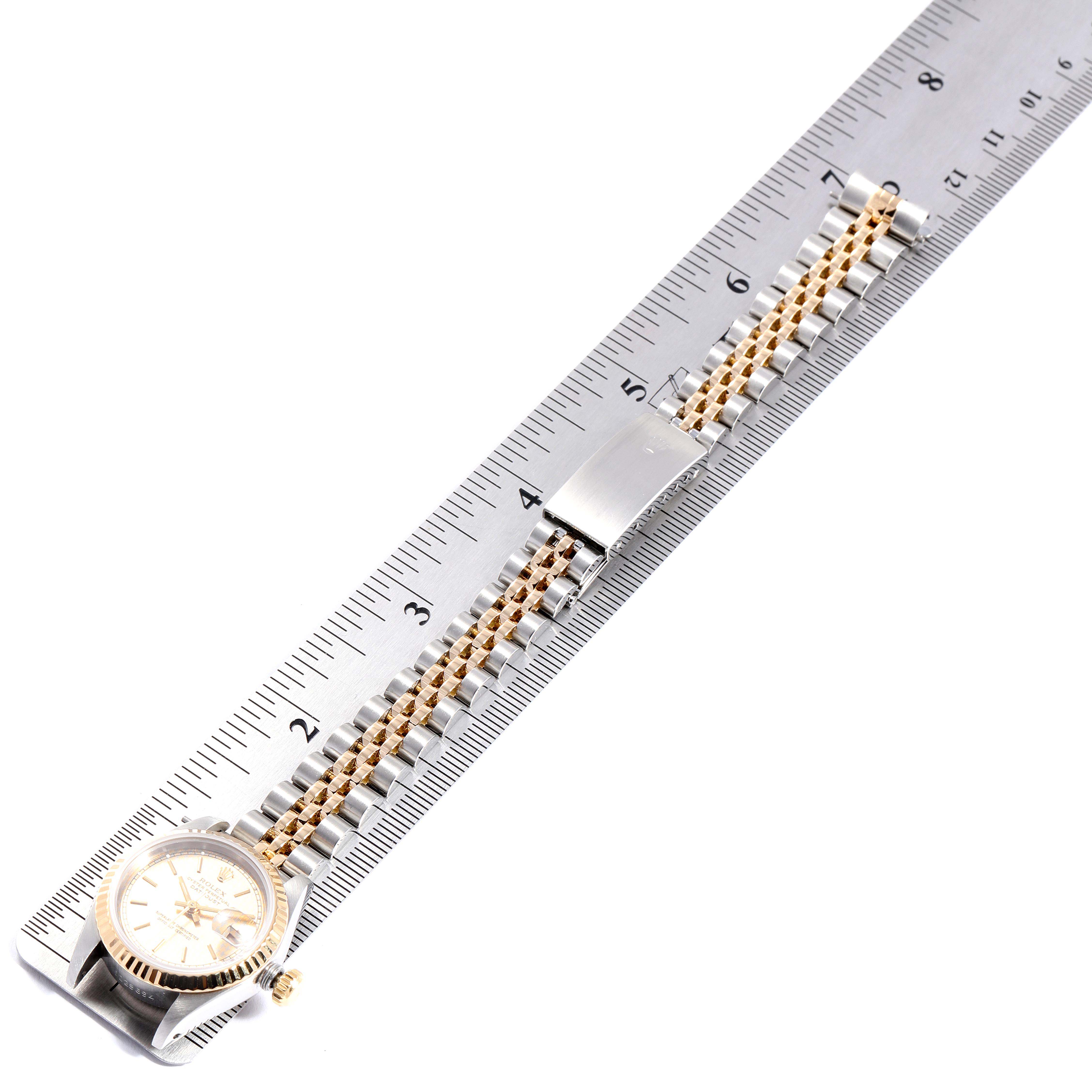 The Rolex Datejust 69173  Women's Stainless Steel Champagne Dial 69173  Women's Stainless Steel Champagne Dial watch is shown from an overhead angle, featuring its case, crown, bracelet, and clasp measured against a ruler.