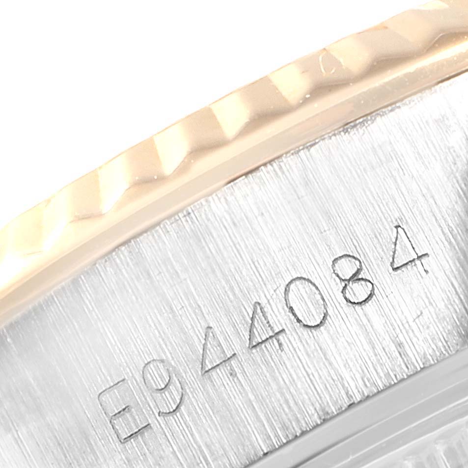 The image shows a close-up of the side of a Rolex Datejust 69173 Women's Stainless Steel Champagne Dial 69173 Women's Stainless Steel Champagne Dial watch, highlighting its serial number and fluted bezel.