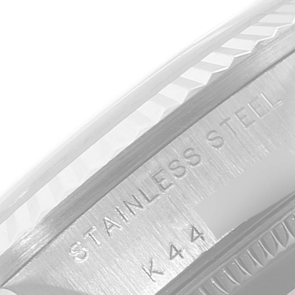 The image shows a close-up angle of the side of a Mid-Size Rolex watch with the "STAINLESS STEEL" engraving and partial model number visible.