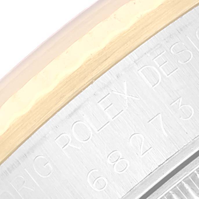 This image shows a close-up of the side of a Mid-Size Rolex watch, specifically the engraved bezel area.
