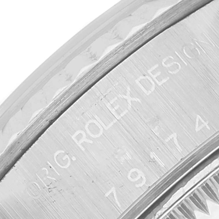 The image shows a close-up of the engraved text on the bezel and case side of a Rolex Datejust 79174 Women's Steel and Gold (two tone) Mother of Pearl Dial 79174 Women's Steel and Gold (two tone) Mother of Pearl Dial watch.