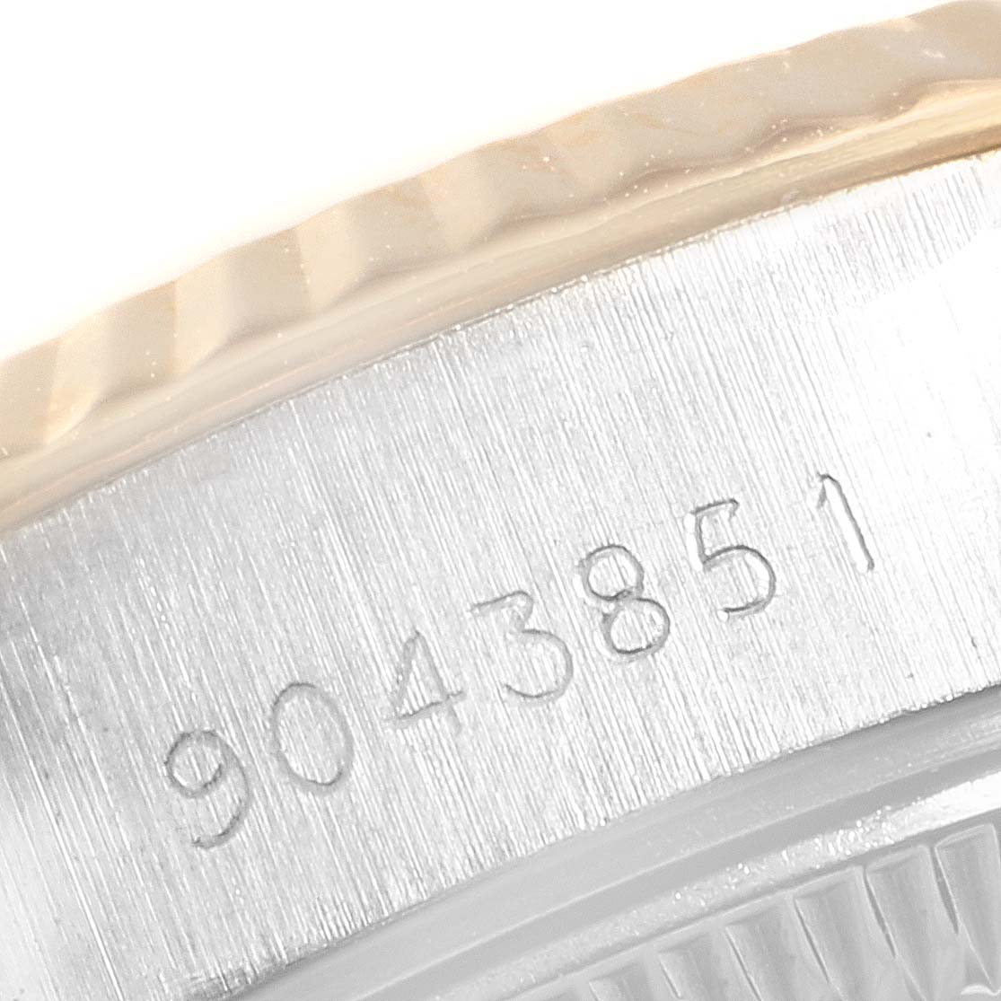 This close-up image of the Rolex 69173 Women's Stainless Steel Beige Dial 69173 Women's Stainless Steel Beige Dial Datejust Steel Yellow Gold Anniversary Dial Ladies Watch 69173 shows its serial number and fluted bezel.