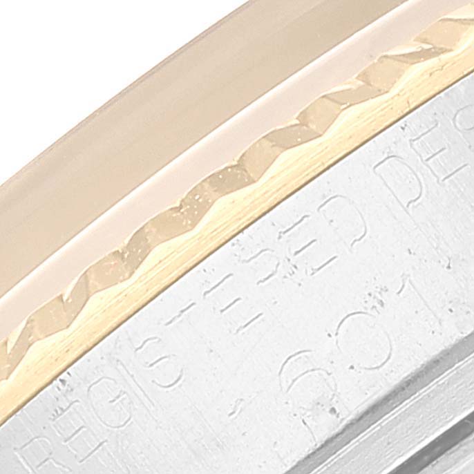 This close-up image shows a partial view of the bezel and engraved case of the Vintage Collection model by Rolex.