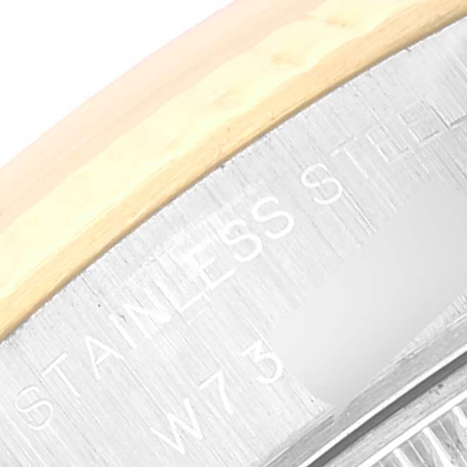 This image shows the edge of a Rolex Datejust 69173 Women's Steel and Gold (two tone) Beige Dial 69173 Women's Steel and Gold (two tone) Beige Dial watch, focusing on the engravings on the stainless steel surface.