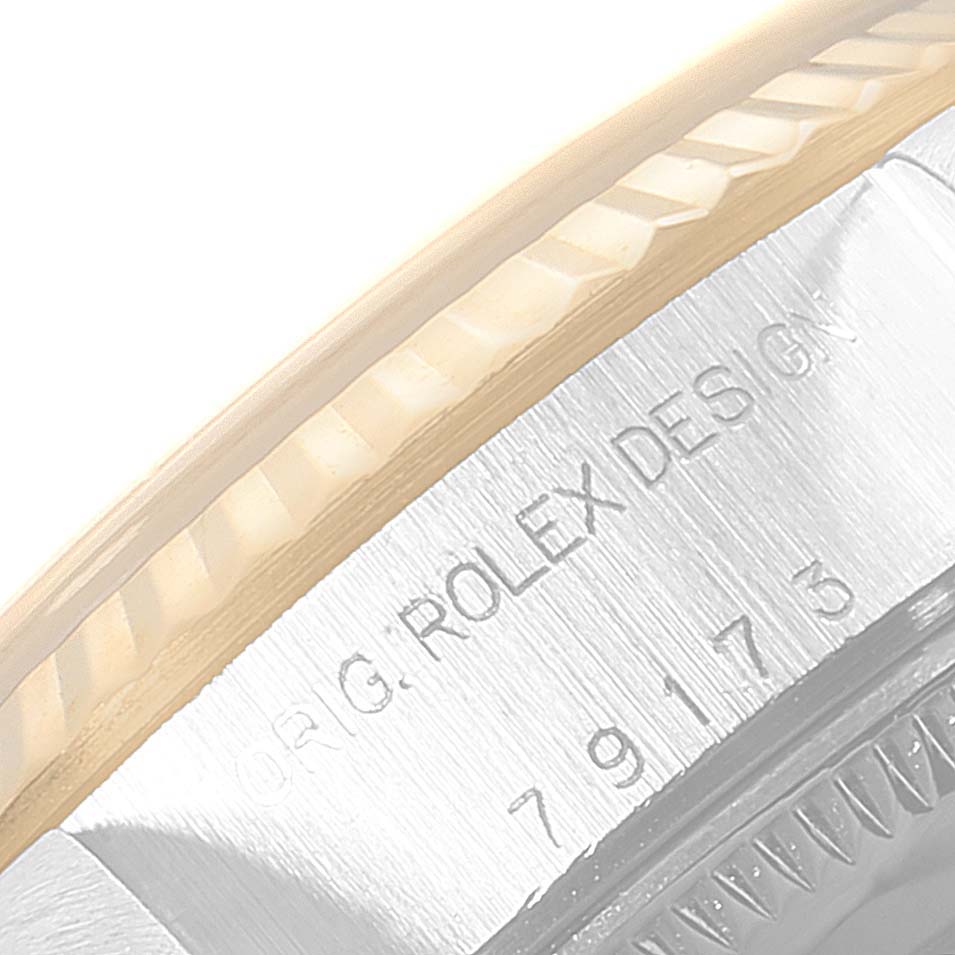 This is a close-up view showing the engraved text and part of the bezel of a Rolex Datejust 79173 Women's Steel and Gold (two tone) Champagne Dial 79173 Women's Steel and Gold (two tone) Champagne Dial watch.
