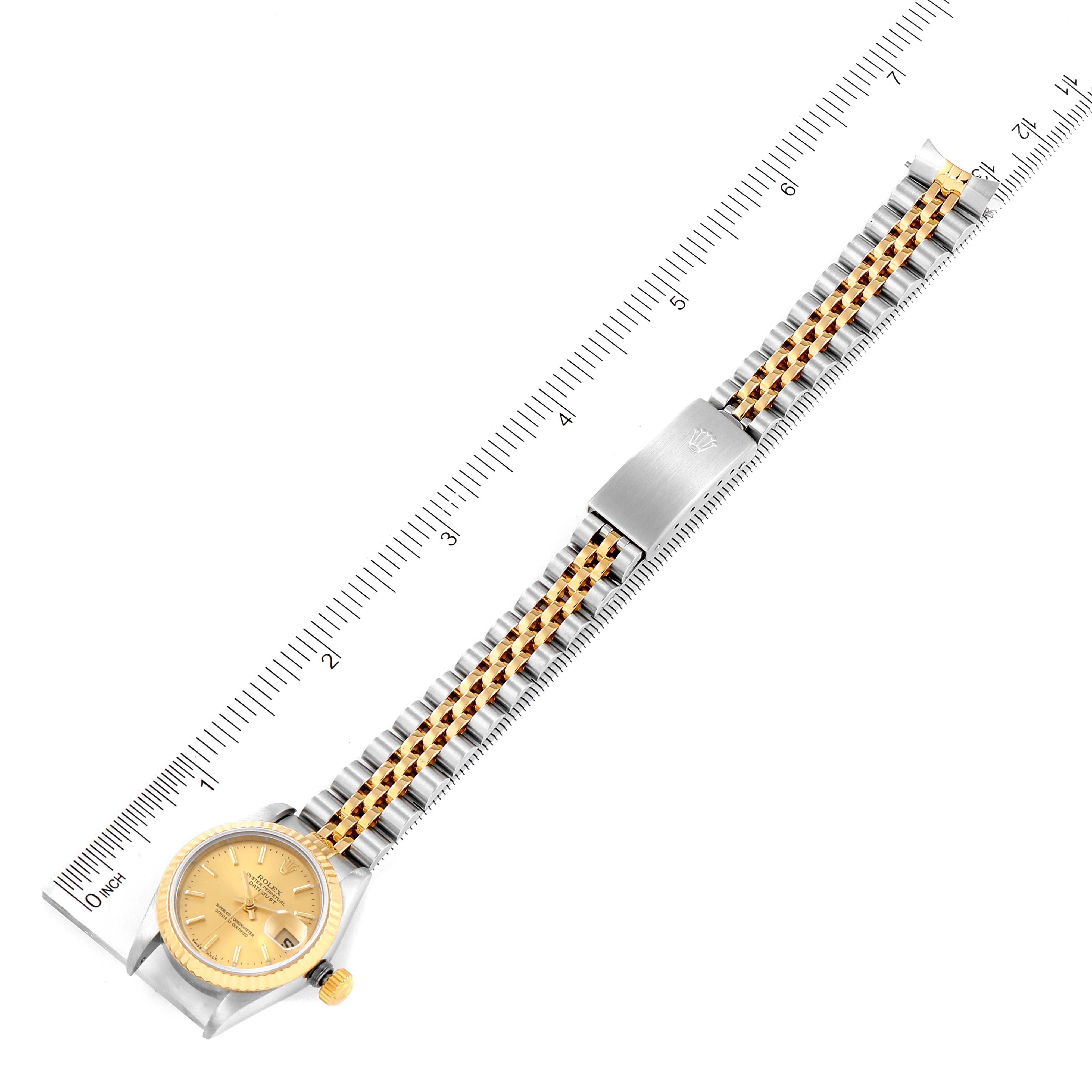 The image shows a top-down view of a Rolex Datejust 79173 Women's Steel and Gold (two tone) Champagne Dial 79173 Women's Steel and Gold (two tone) Champagne Dial watch, displaying its entire bracelet and dial alongside measuring rulers.