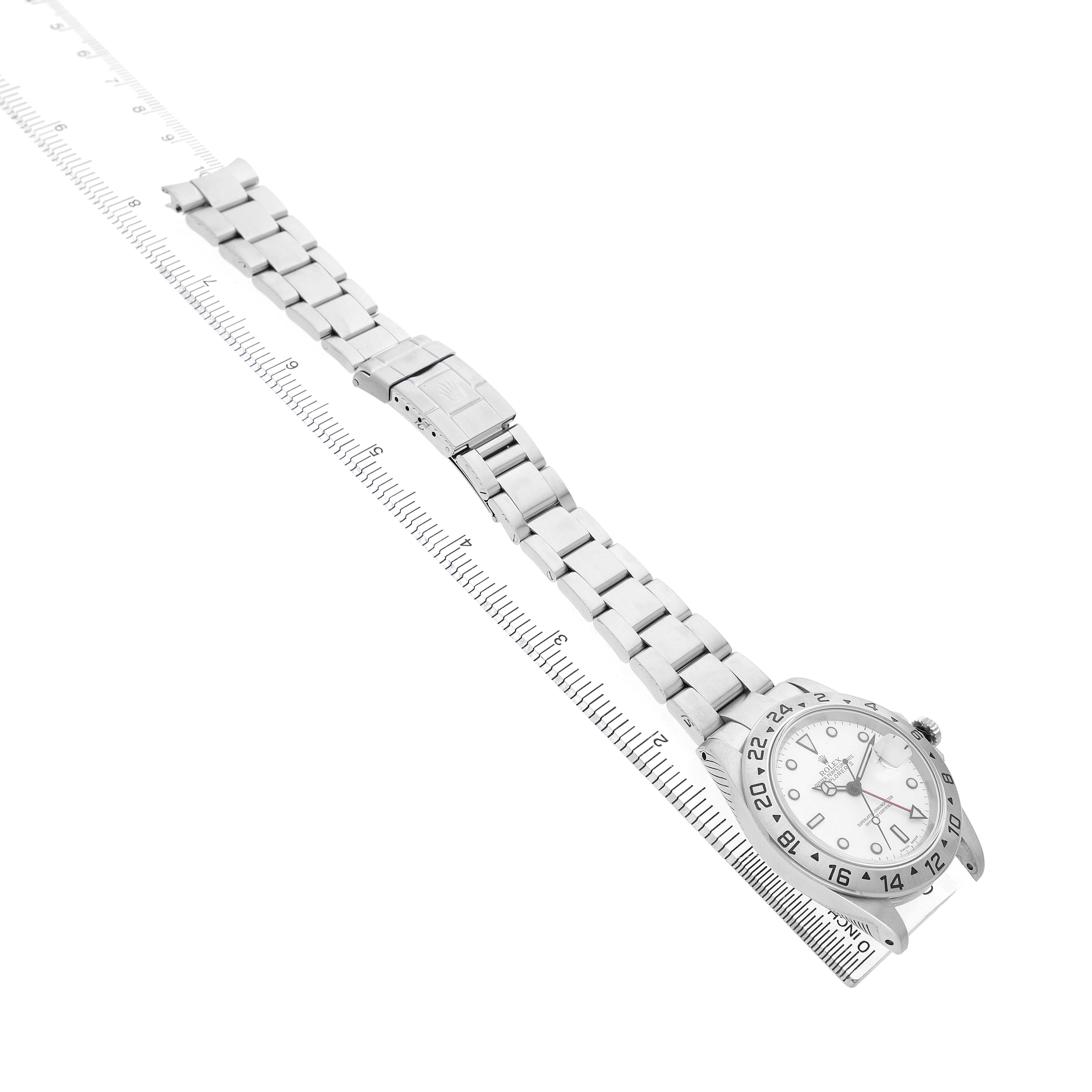 The image shows the Rolex Explorer 16570 Men's Stainless Steel White Dial watch laid flat with a focus on its face and bracelet, displayed diagonally with a ruler alongside.