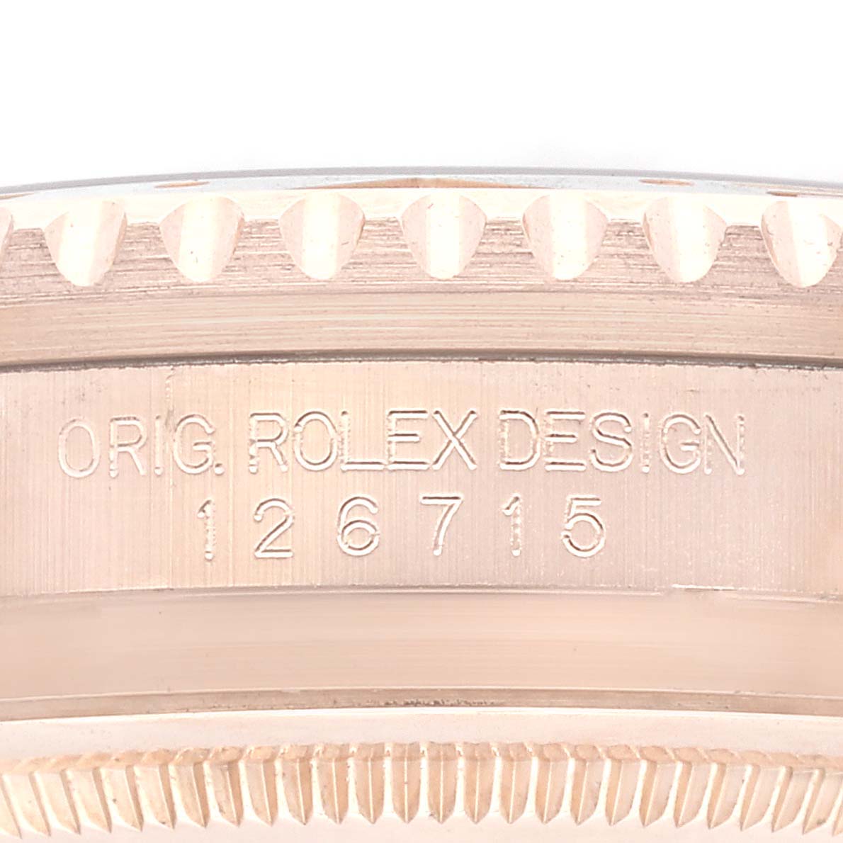 This close-up photo shows the case side of a Rolex GMT-Master 126715CHNR Men
s Rose Gold Black Dial 126715CHNR Men
s Rose Gold Black Dial, highlighting the model number 126715 and "ORIG. ROLEX DESIGN" engraving.