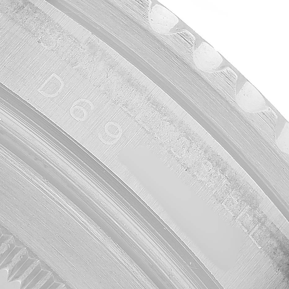 The image shows a close-up of the bezel's edge and engraved text on a Rolex GMT-Master 16710 Men's Stainless Steel Black Dial watch.