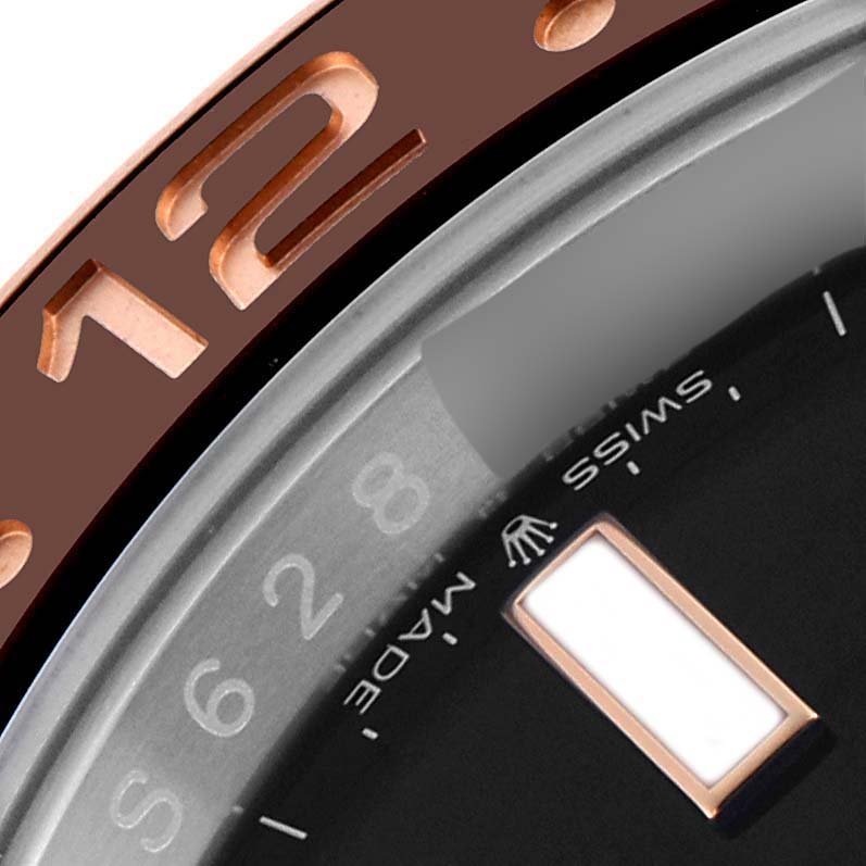 The image shows a close-up of the bezel and part of the dial of a Rolex GMT-Master 126711CHNR Men's Steel and Gold (two tone) Black Dial 126711CHNR Men's Steel and Gold (two tone) Black Dial, including the 12 numeral and "Swiss Made" text.