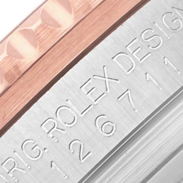 The image shows a close-up of the engraved side of a Rolex GMT-Master 126711CHNR Men's Steel and Gold (two tone) Black Dial 126711CHNR Men's Steel and Gold (two tone) Black Dial watch, focusing on the edge of the bezel and the casing.