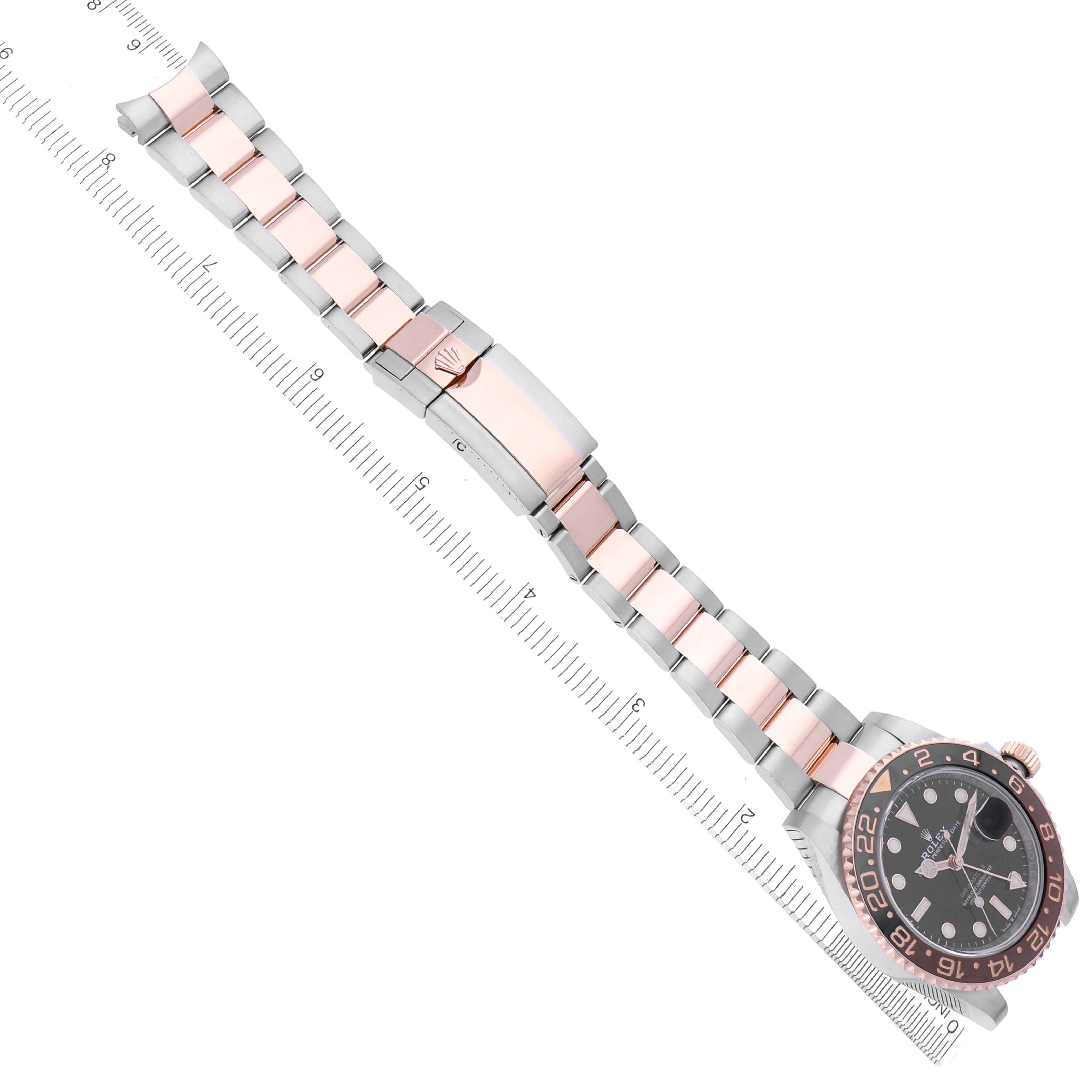 The Rolex GMT-Master 126711CHNR Men's Steel and Gold (two tone) Black Dial 126711CHNR Men's Steel and Gold (two tone) Black Dial watch is shown from an angled view with its bracelet and dial fully visible alongside a ruler for scale.