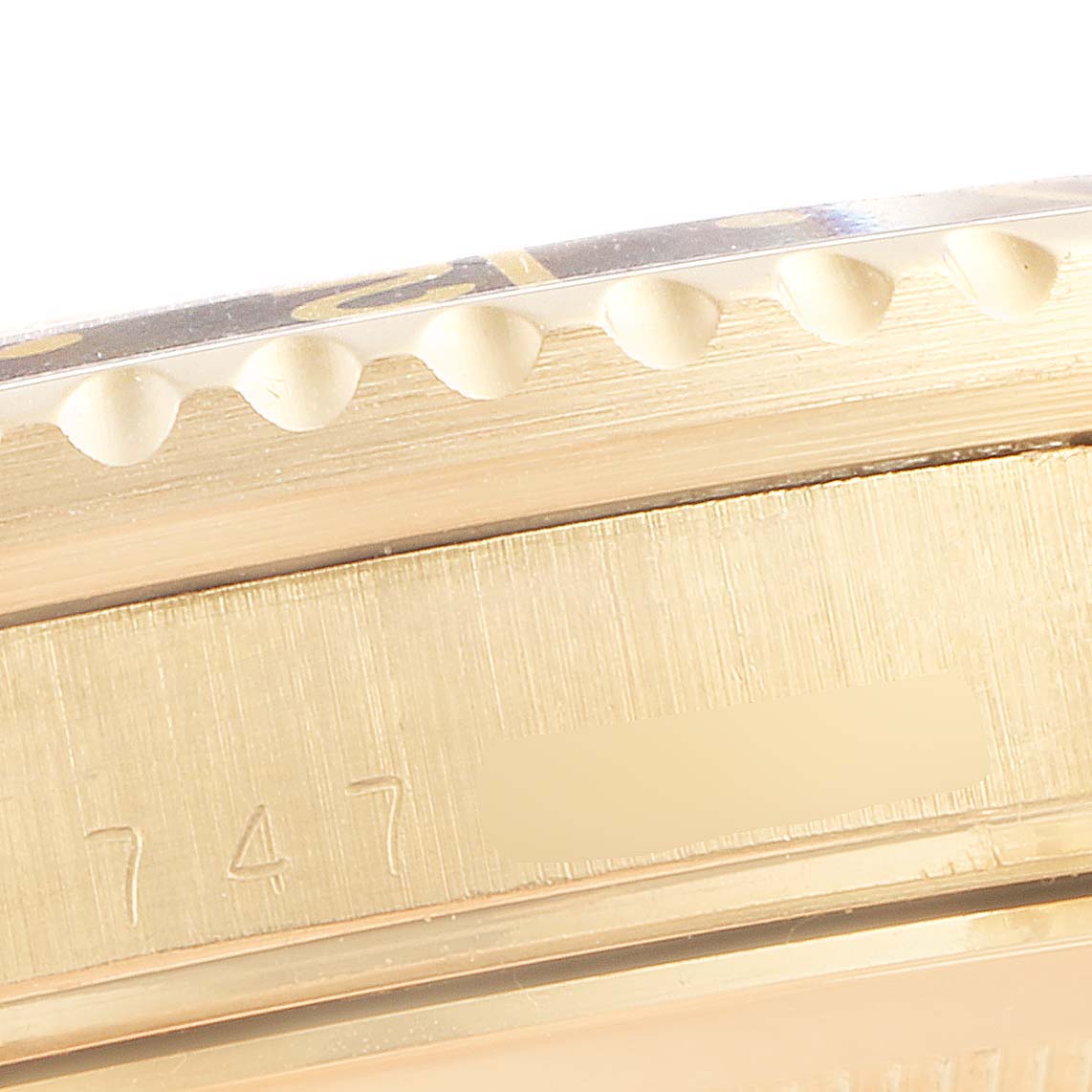 The image shows a close-up of the side of the Rolex GMT-Master 16758 Men's Yellow Gold Brown Dial 16758 Men's Yellow Gold Brown Dial, highlighting its engraved case serial number and bezel edge.
