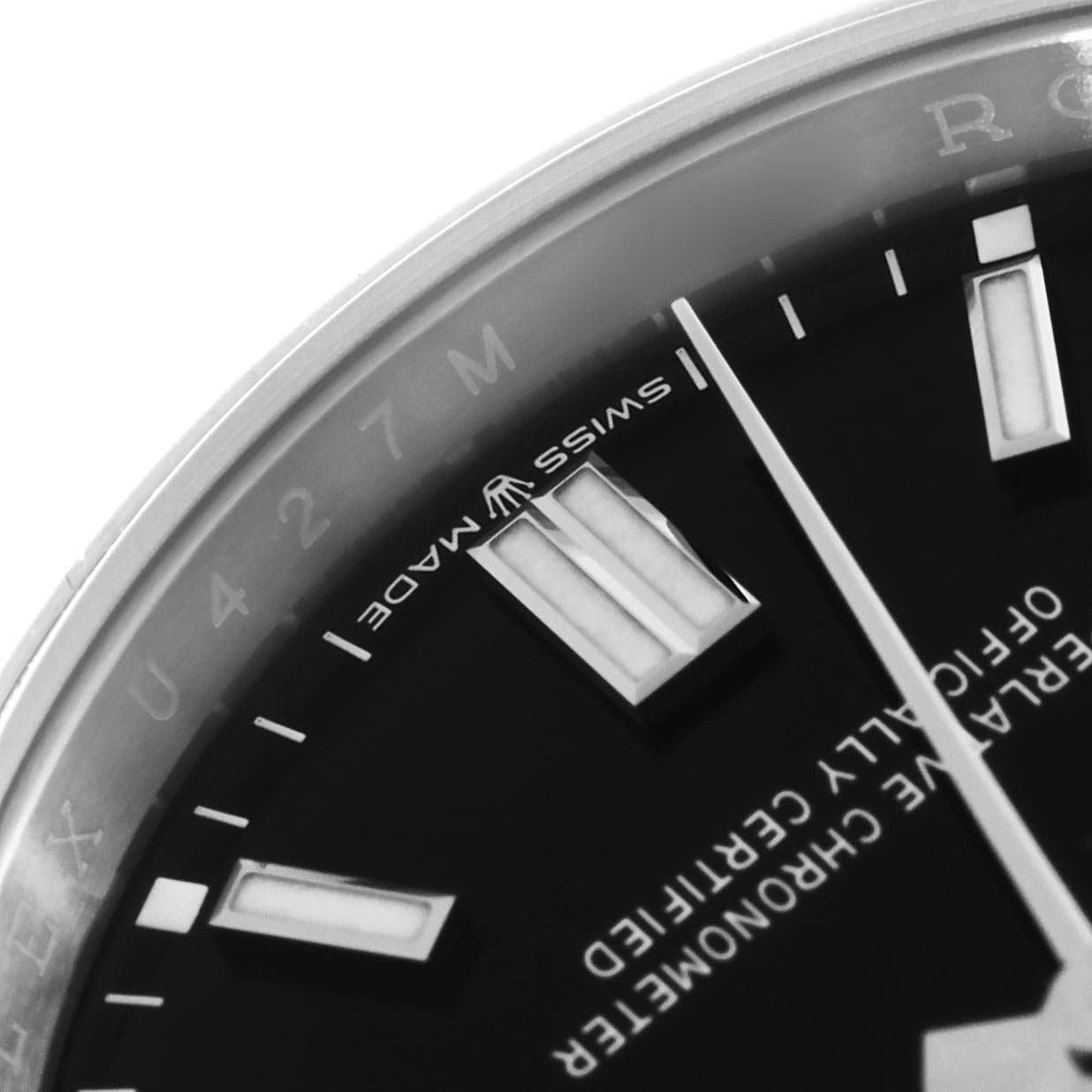 The image shows a close-up of the dial on an Oyster Perpetual Rolex watch, featuring the hour markers, hands, and "Swiss Made" text.