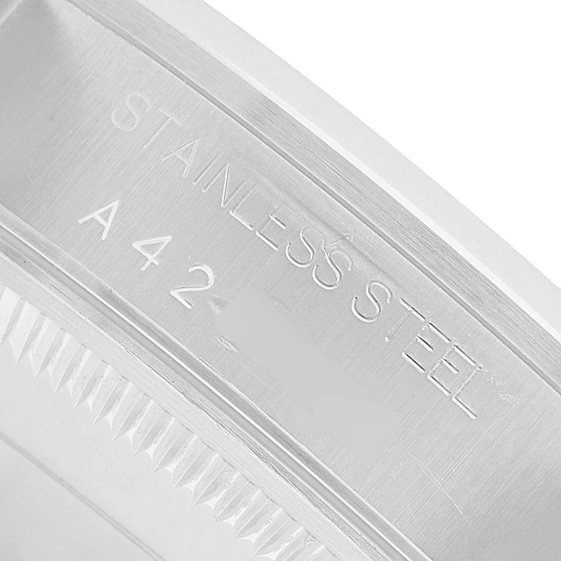 The image shows a close-up of the engraving on the side of a stainless steel case of a Rolex Date 15200 Men's Stainless Steel Black Dial model.