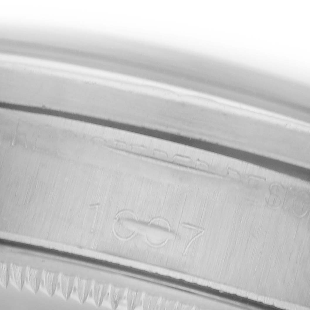 The image shows a close-up of the engraved inner bezel of a Rolex Oyster Perpetual 1007 Men's Stainless Steel Silver Dial 1007 Men's Stainless Steel Silver Dial watch.