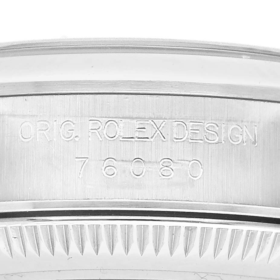 This image shows the engraved bezel or case back edge of the Rolex Oyster Perpetual 76080 Women's Stainless Steel Black Dial watch, highlighting the model number.