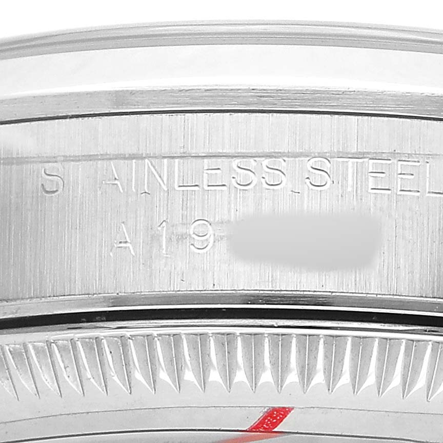The image shows a close-up of the bezel and side engraving of a Rolex Oyster Perpetual 76080 Women's Stainless Steel Black Dial, displaying "STAINLESS STEEL" text.