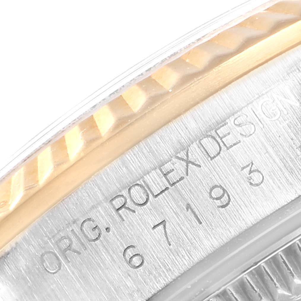 This close-up image shows part of the bezel and case back of a Rolex Oyster Perpetual 67193 Women's Stainless Steel Champagne Dial 67193 Women's Stainless Steel Champagne Dial watch displaying the engraved model number.
