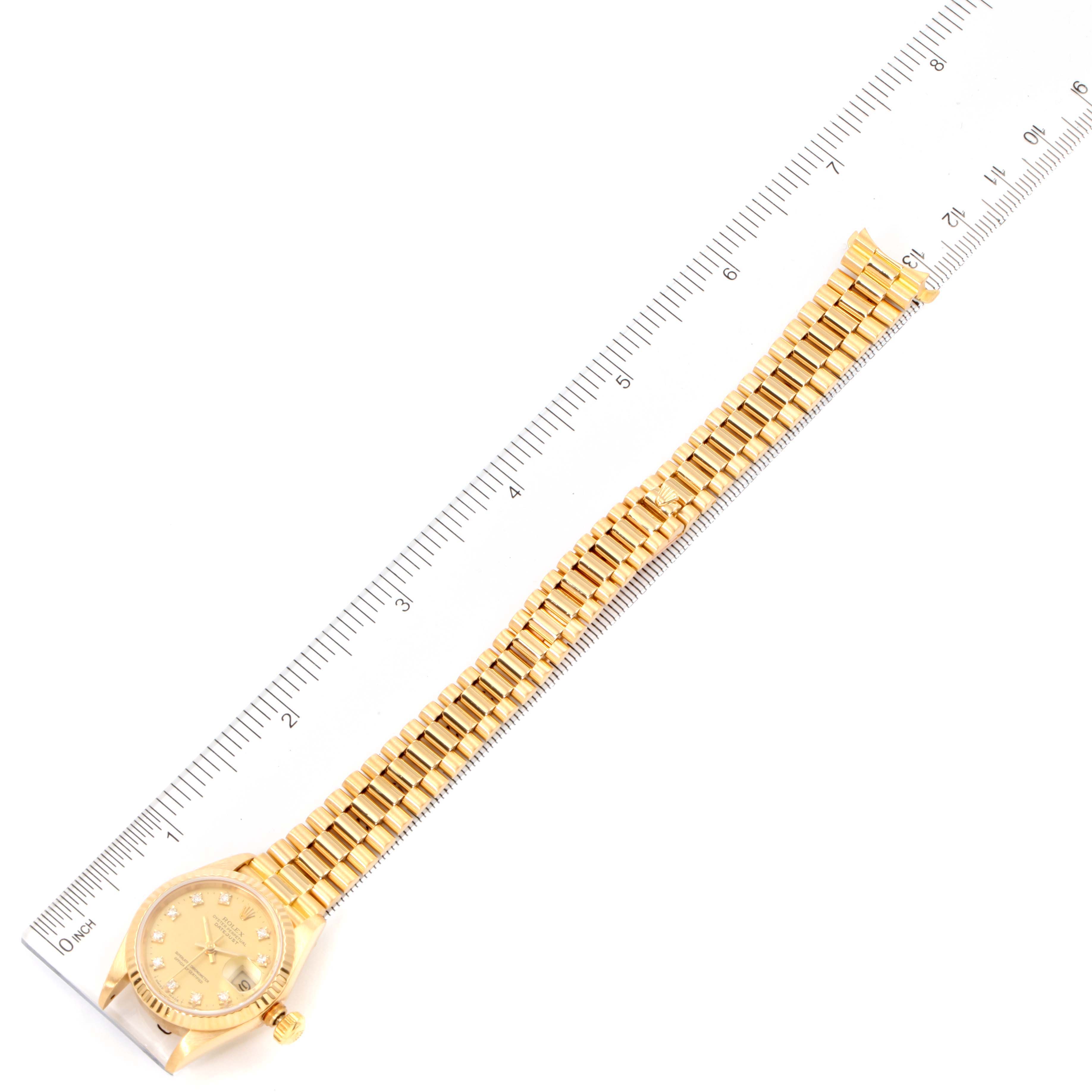 The image shows a full view of a Rolex President 69178 Women's Yellow Gold Champagne Dial 69178 Women's Yellow Gold Champagne Dial model watch next to a ruler for measurement.