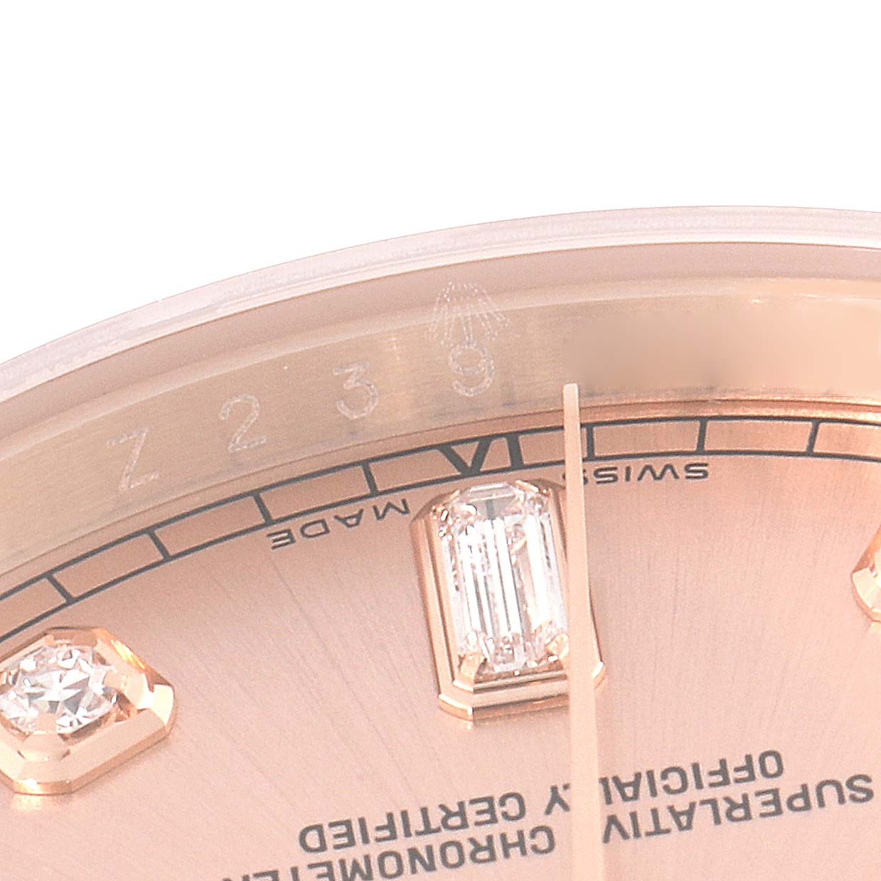 This image shows a close-up view of the dial of a Rolex President 118235 Men's Rose Gold Pink Dial 118235 Men's Rose Gold Pink Dial model, focusing on diamonds, Roman numerals, and text details.