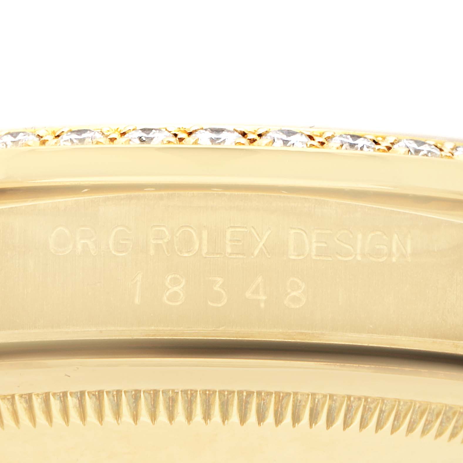 The image shows a close-up of the edge and engraving on the Rolex President 18348 Men's Yellow Gold Champagne Dial 18348 Men's Yellow Gold Champagne Dial watch case, focusing on the brand mark and design number.