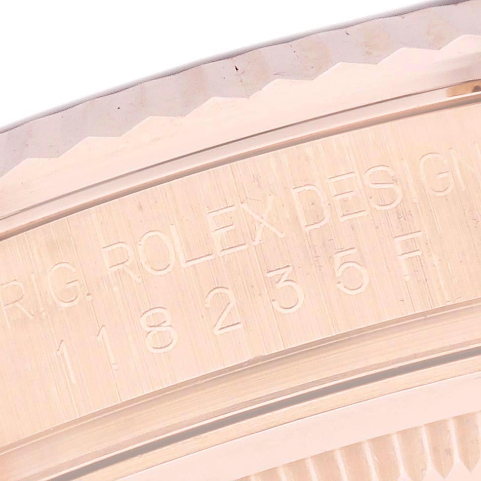 The image shows a close-up of the serialized edge engraving on the bezel of a Rolex President 118235 Men's Rose Gold Silver Dial 118235 Men's Rose Gold Silver Dial watch.