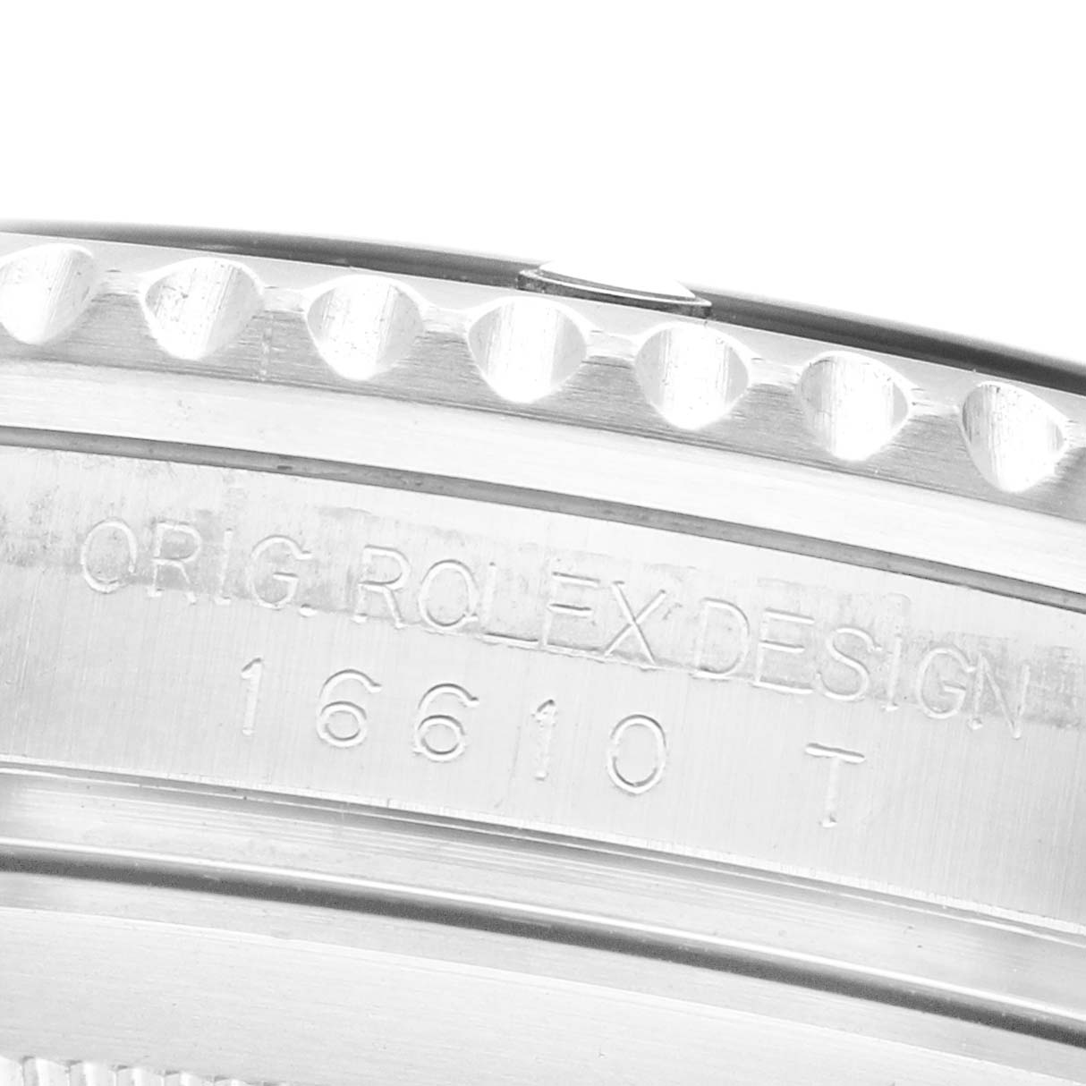 The image shows a close-up of the engraved bezel and side of a Rolex Submariner 16610 Men's Stainless Steel Black Dial watch, highlighting the original design text and model number.